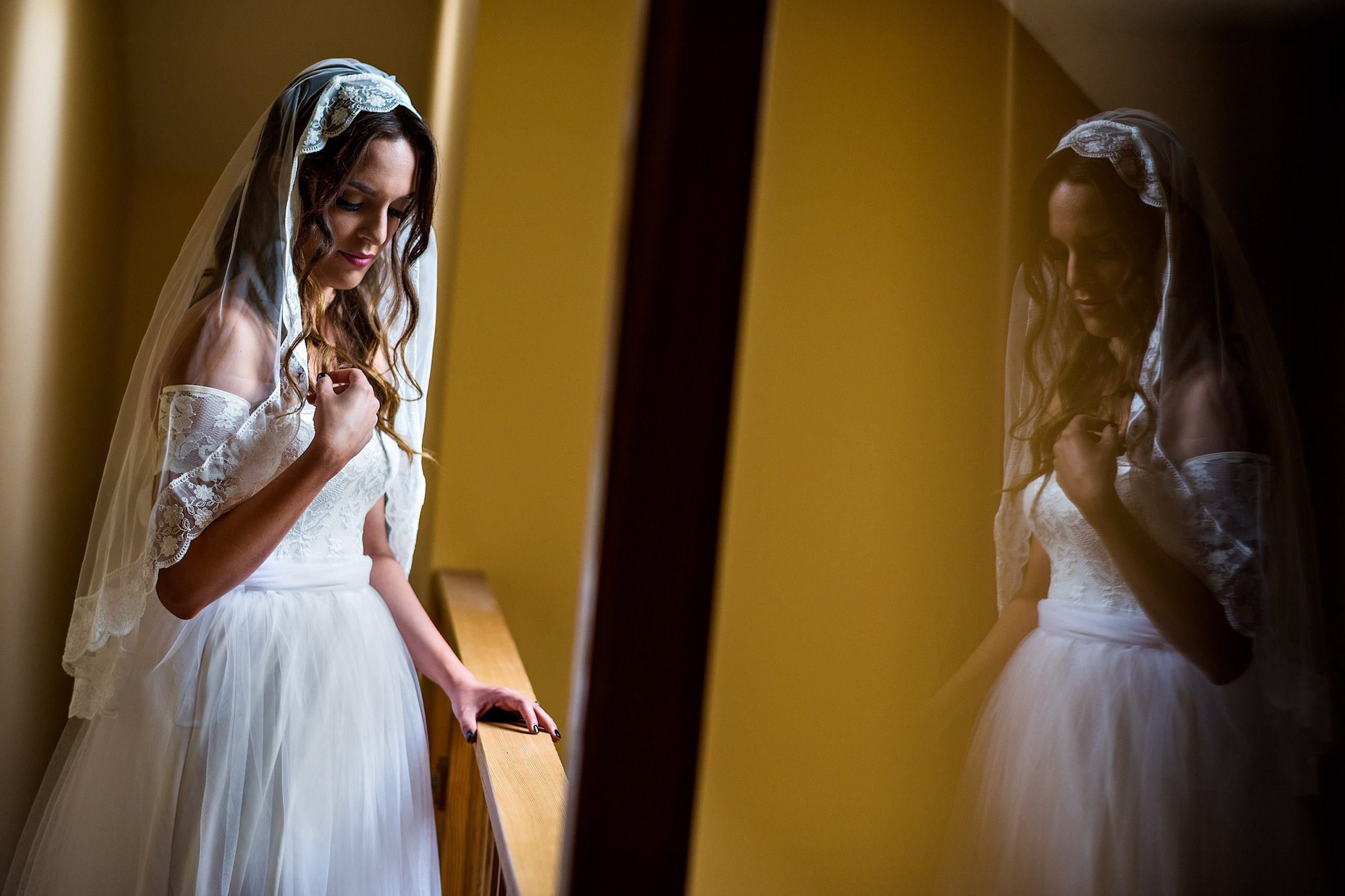 a bride posing in front of a hall way - a room of bridesmaids getting ready - Qualicum Wedding Photographer