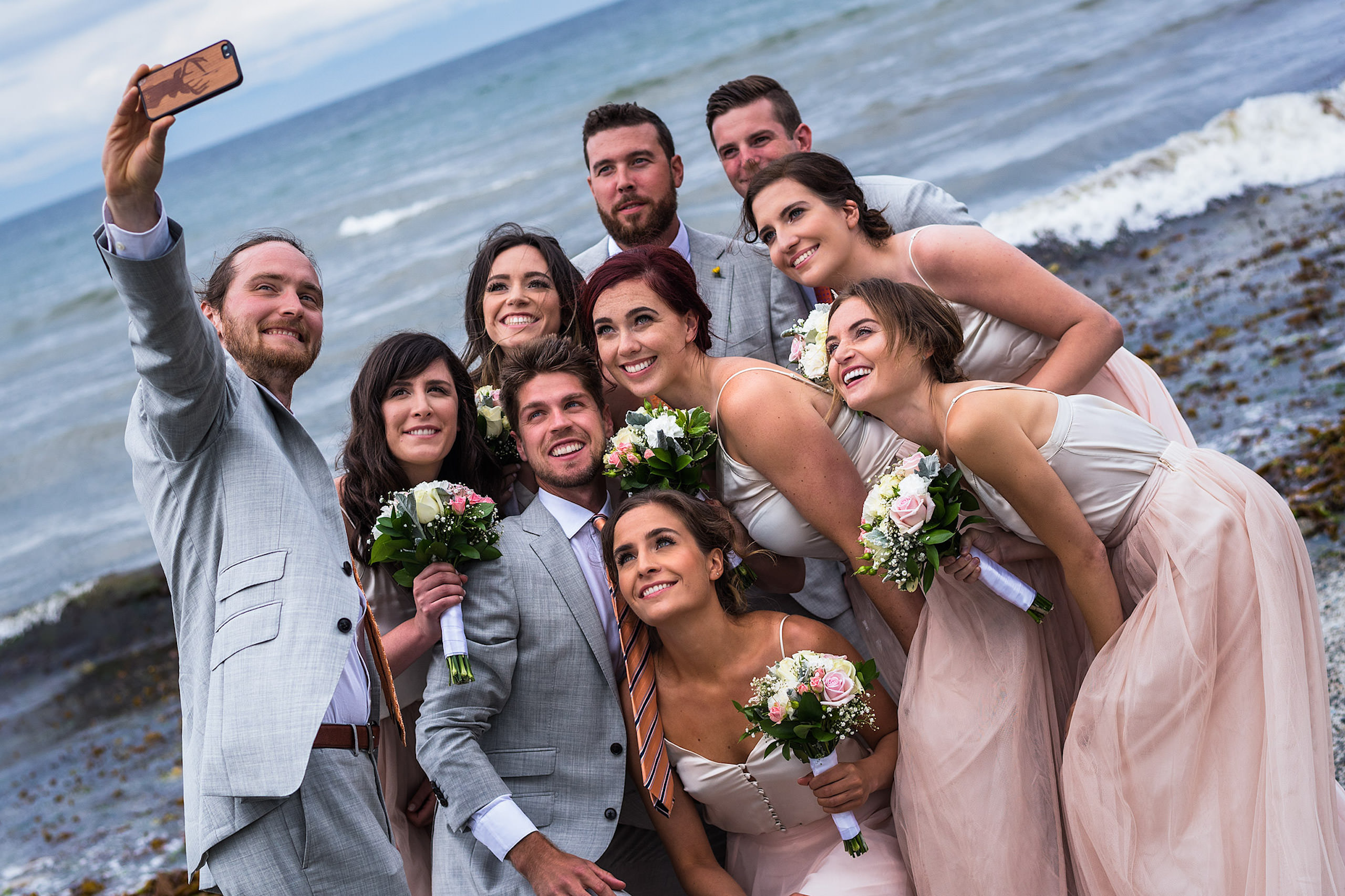 A wedding party posing for a photograph on a beach in BC - Qualicum Wedding Photographer