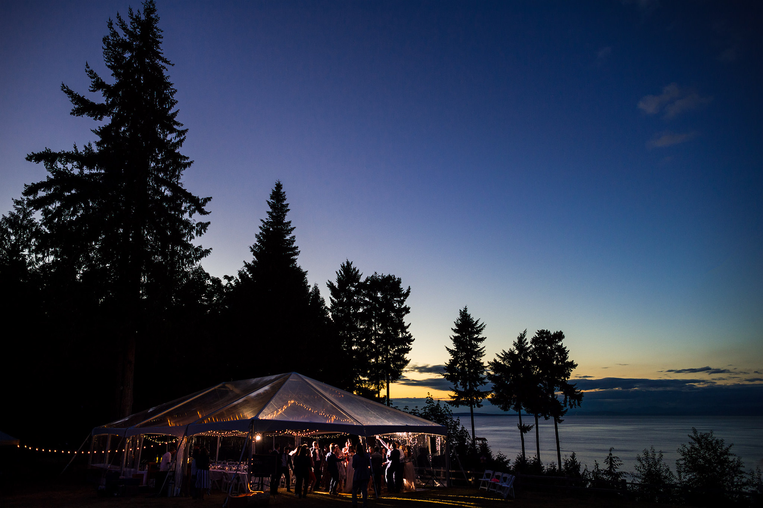 Wide angle photograph of a tent at a wedding reception in low light - Qualicum Wedding Photographer