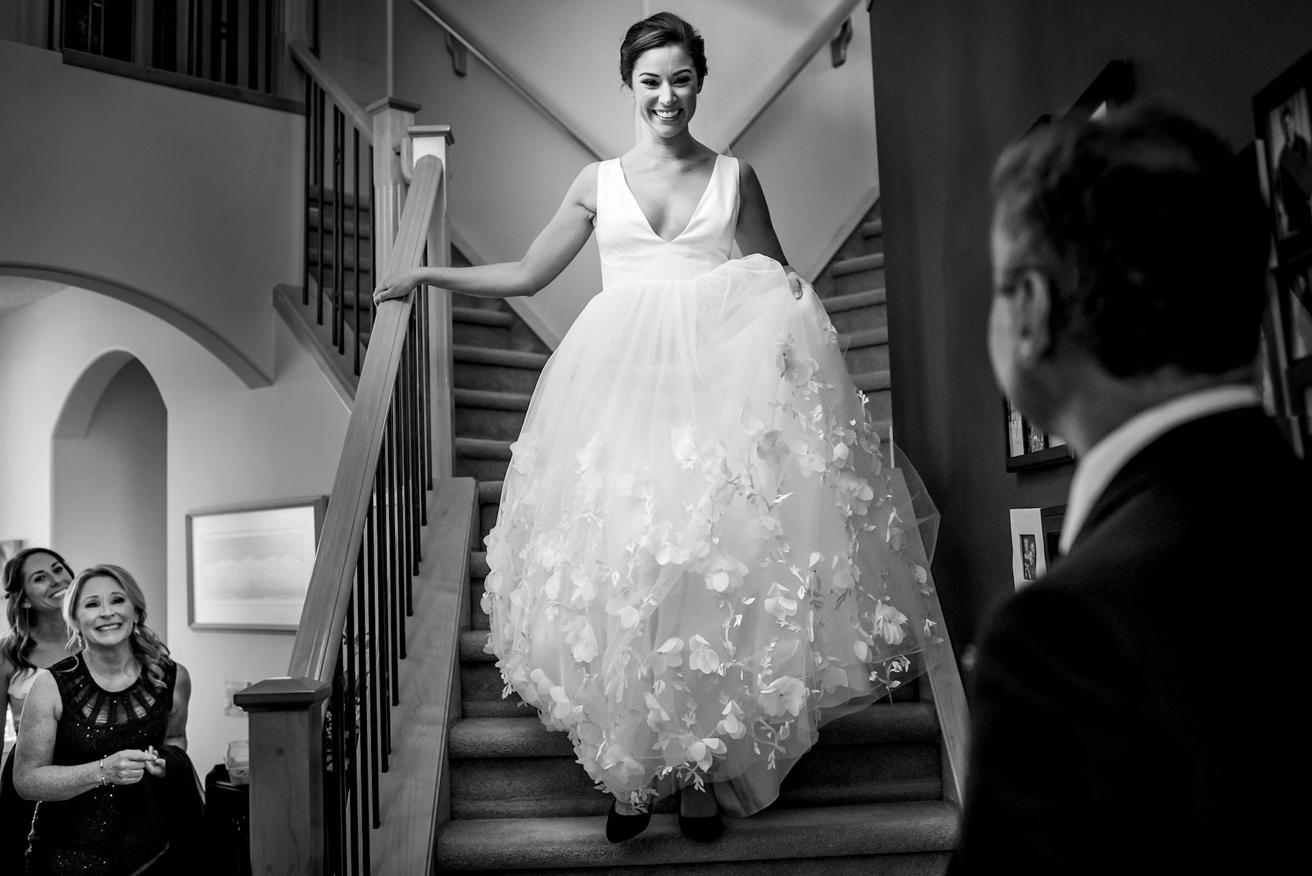 a bride walking down stairs seeing her dad for the first time on her wedding day by calgary wedding photographers