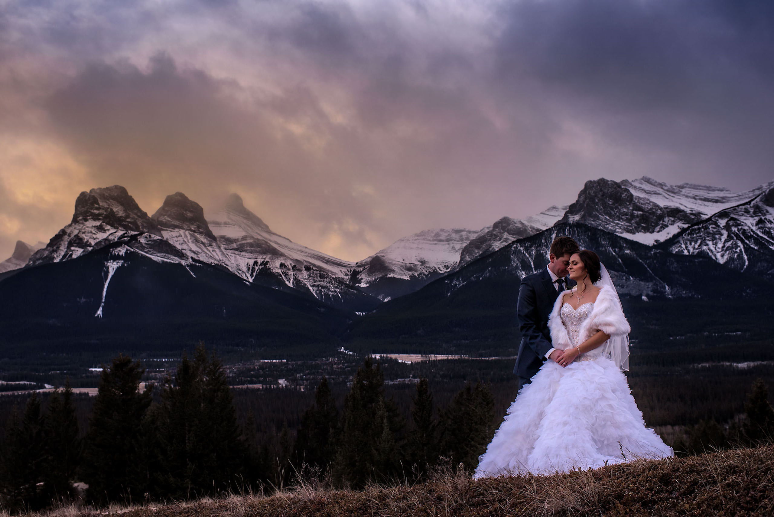 bride and groom embracing at the top of a mountain by Canmore wedding photographer
