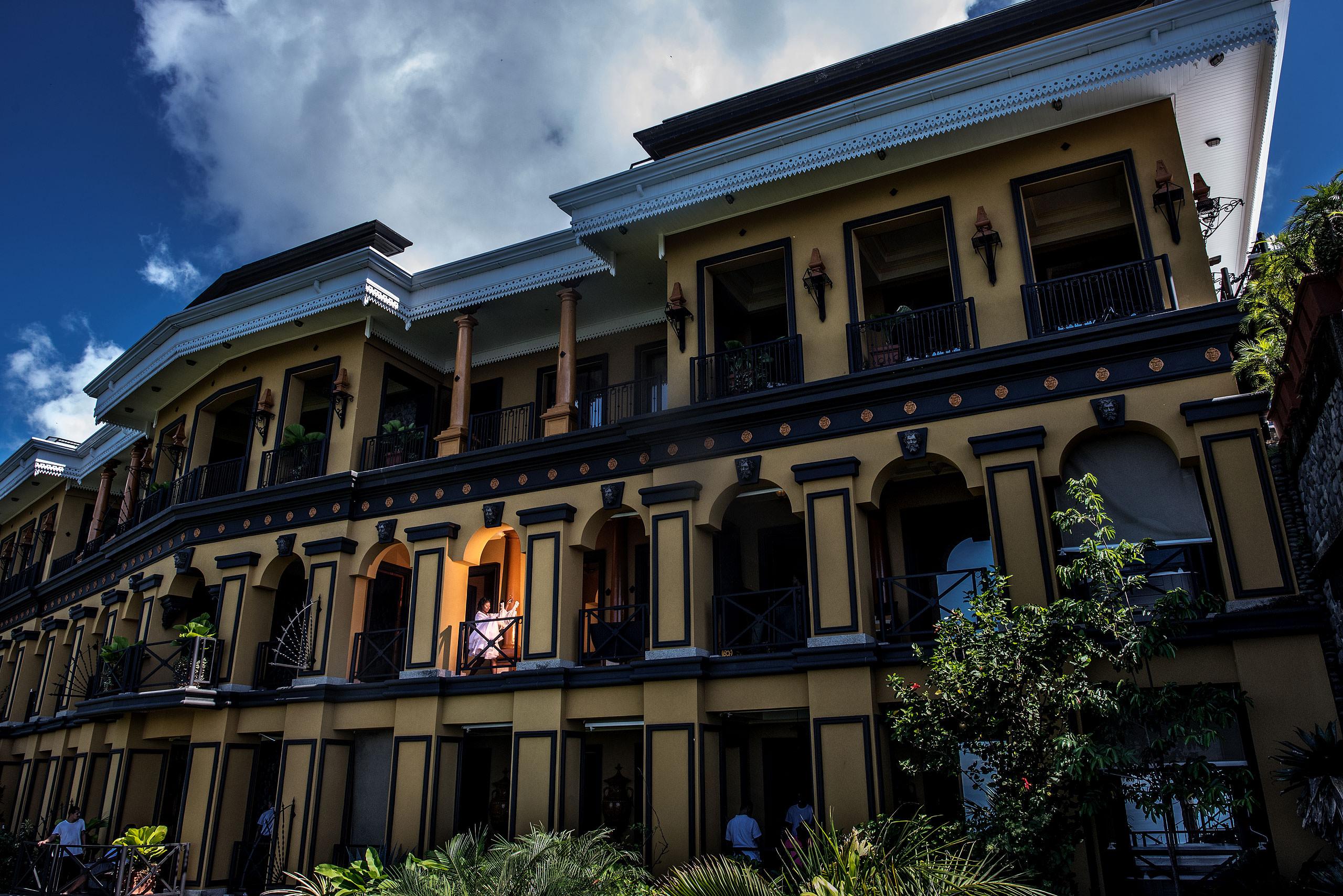 a bride walking with her dress on a balcony at Zephyr Palace Destination Wedding in Costa Rica by Sean LeBlanc