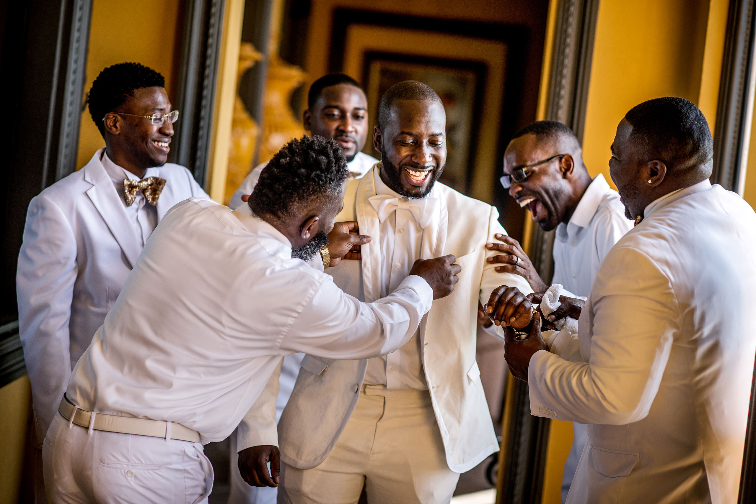 groomsmen joking around while getting ready for a wedding by destination wedding photographer