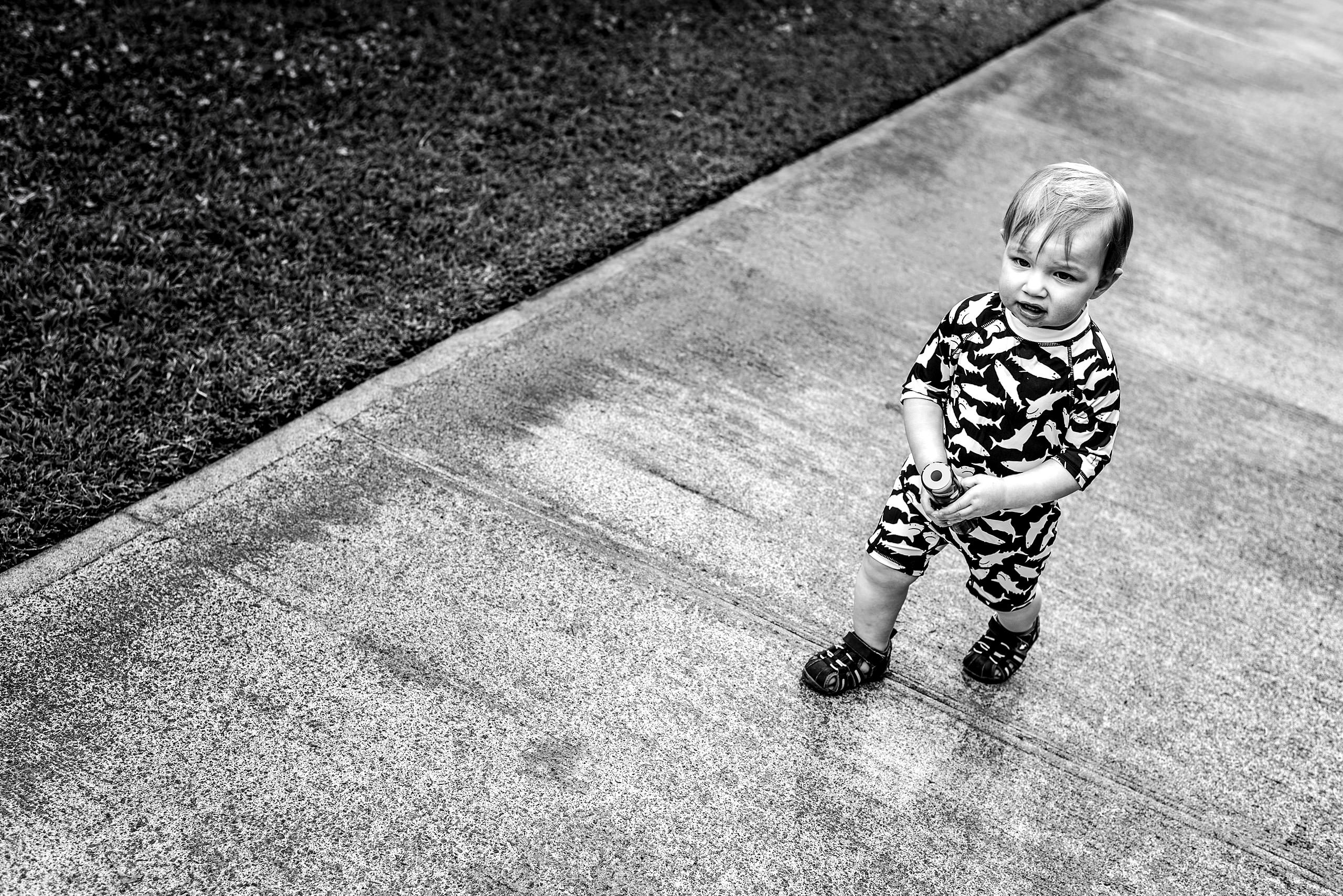 a young boy walking in his bathing suit on the sidewalk by destination family photographers sean leblanc