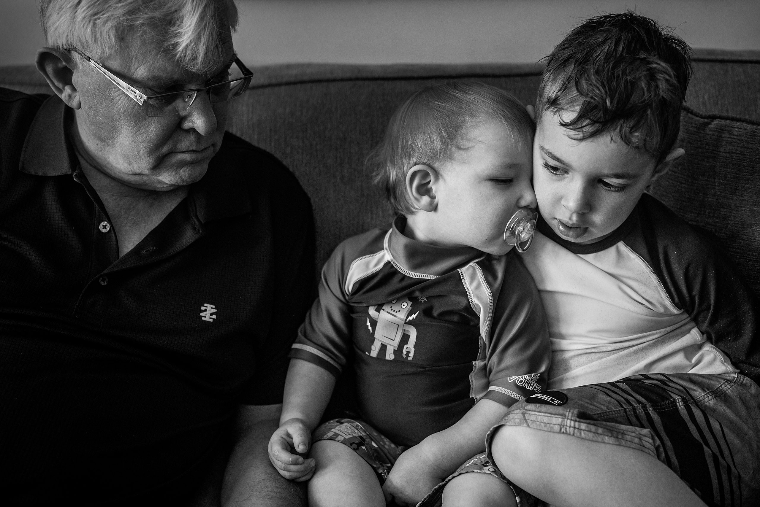 two young boys sitting on a couch together by destination family photographers sean leblanc