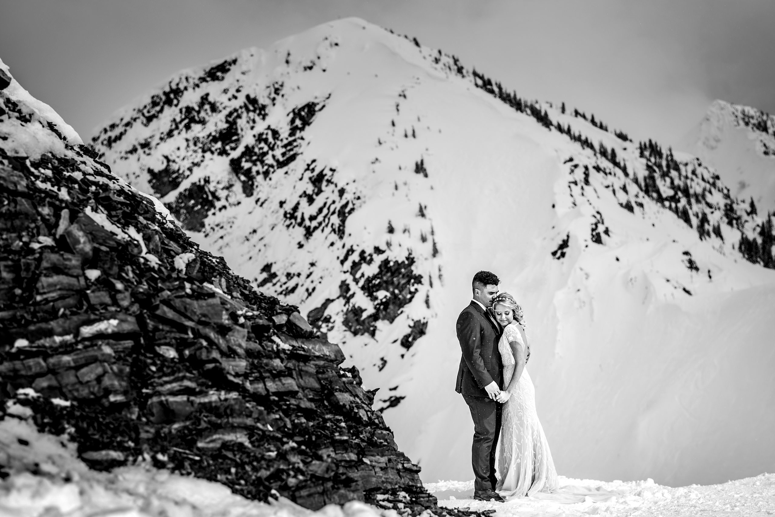 a bride and groom holding each other at a winter kicking horse wedding by sean leblanc