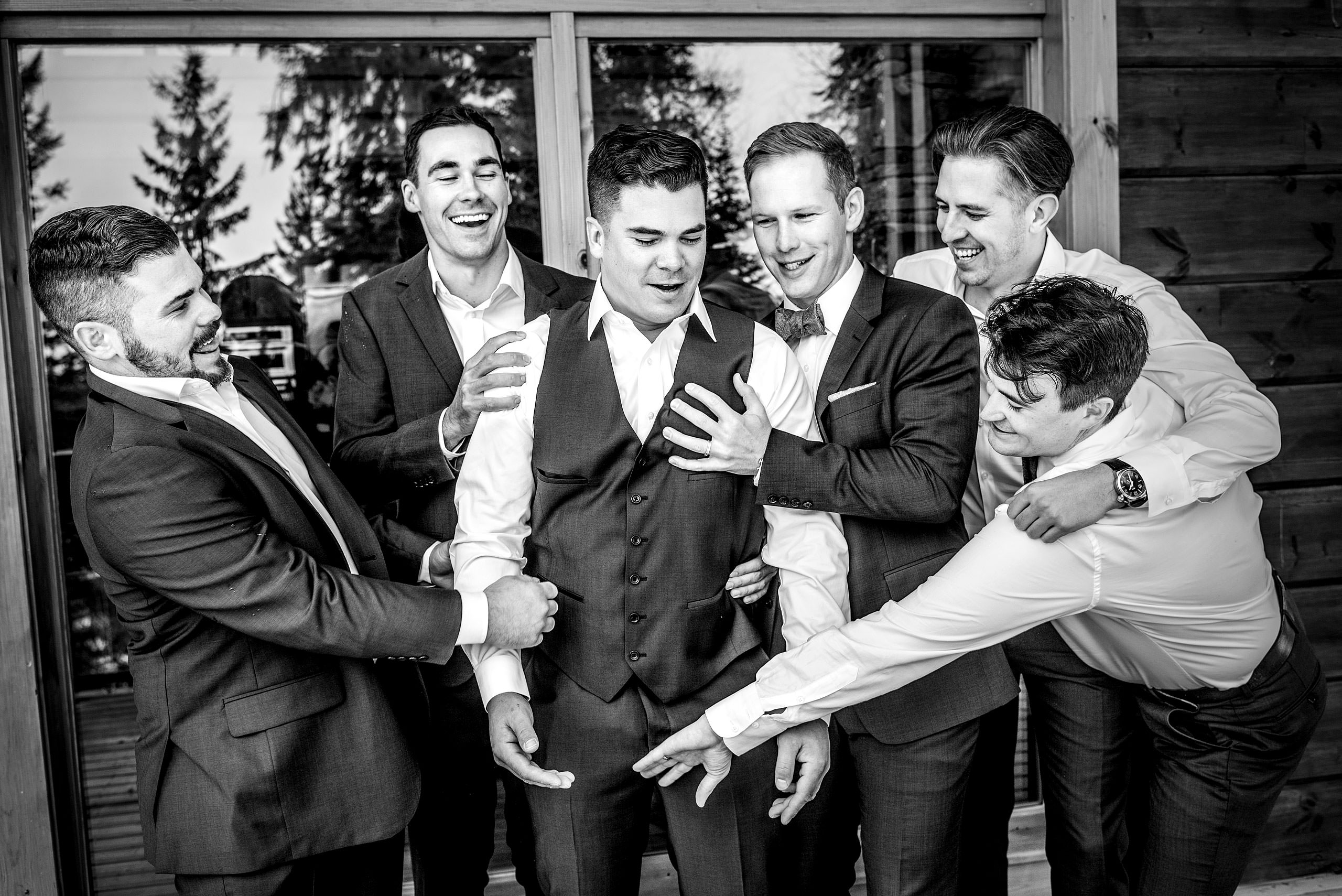 groomsmen posing on a deck at summer kicking horse wedding