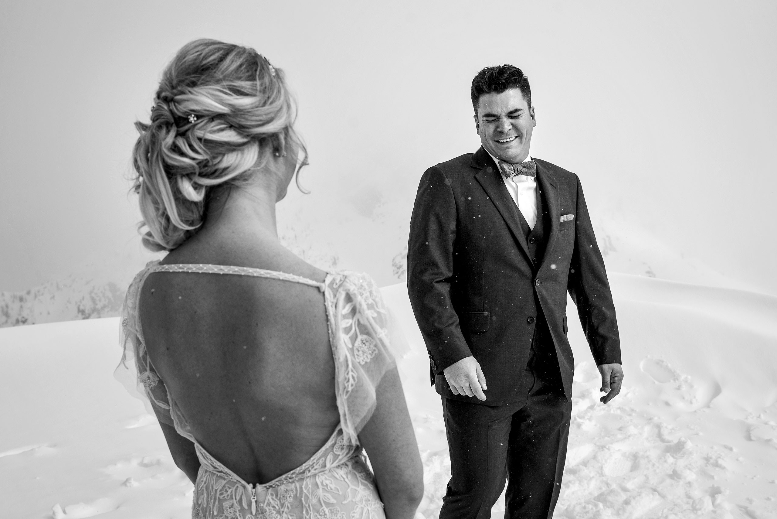 a groom crying tears of joy from seeing his bride for the first time at a winter kicking horse wedding by sean leblanc