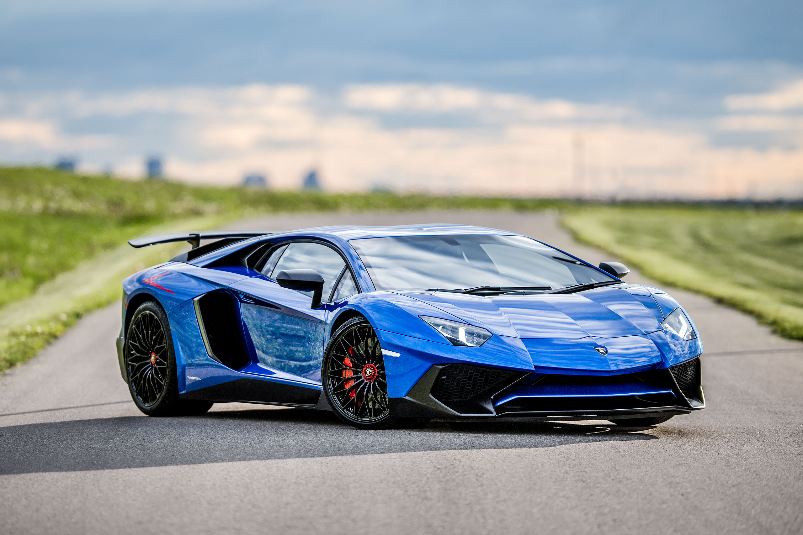 metallic blue Lamborghini aventador with the doors open parked on a road