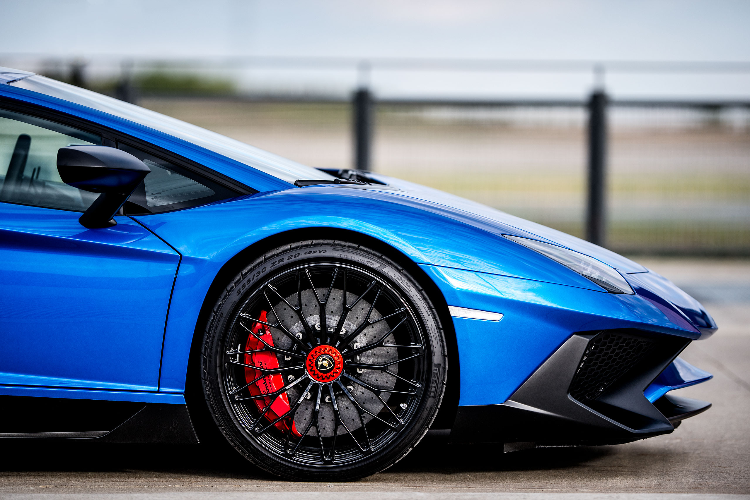 metallic blue Lamborghini aventador with the doors open parked on a road