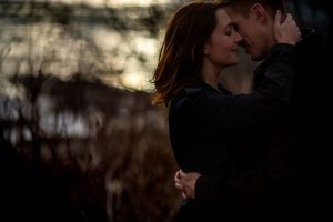 a man and a women embracing by a river at a Calgary East Village Engagement Session