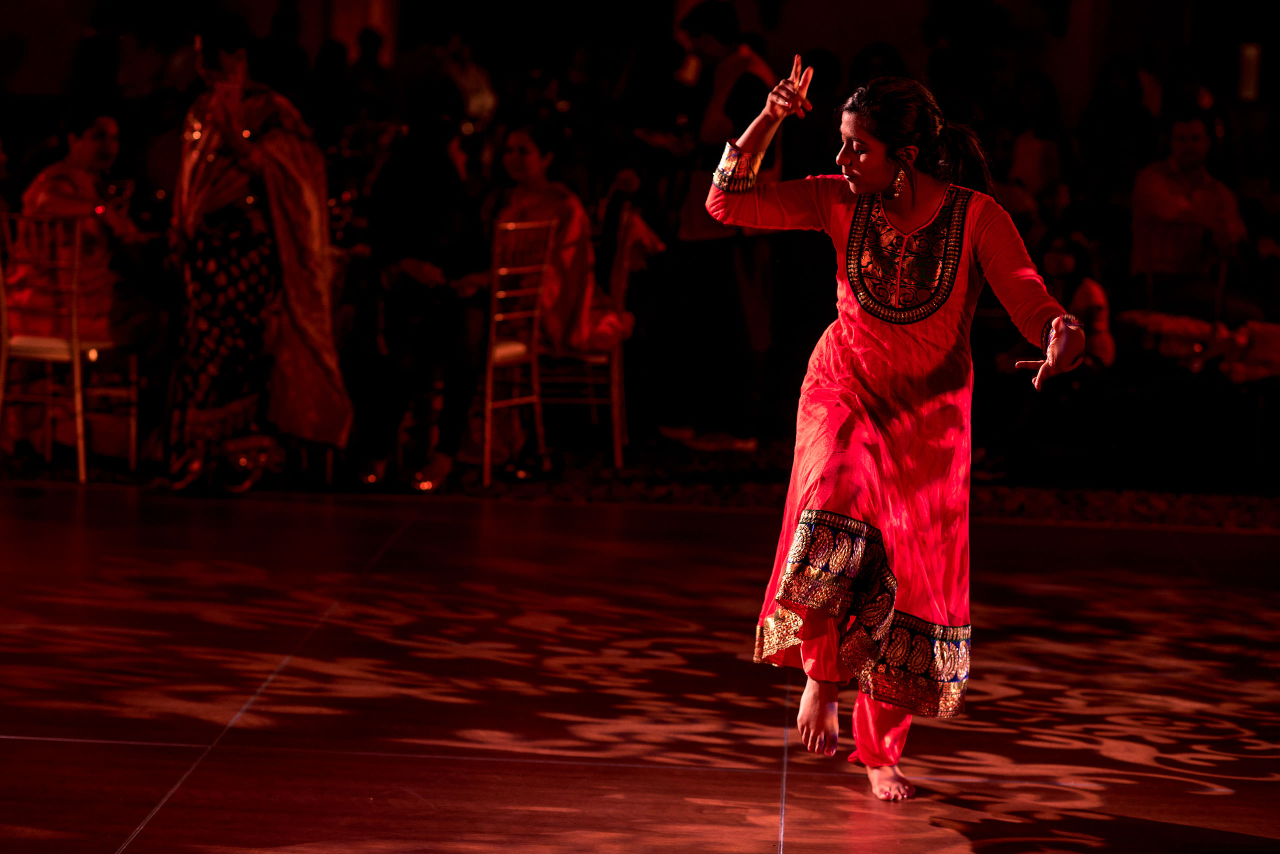 an indian women in a red dress dancing for cascade ballroom banff springs wedding by sean leblanc
