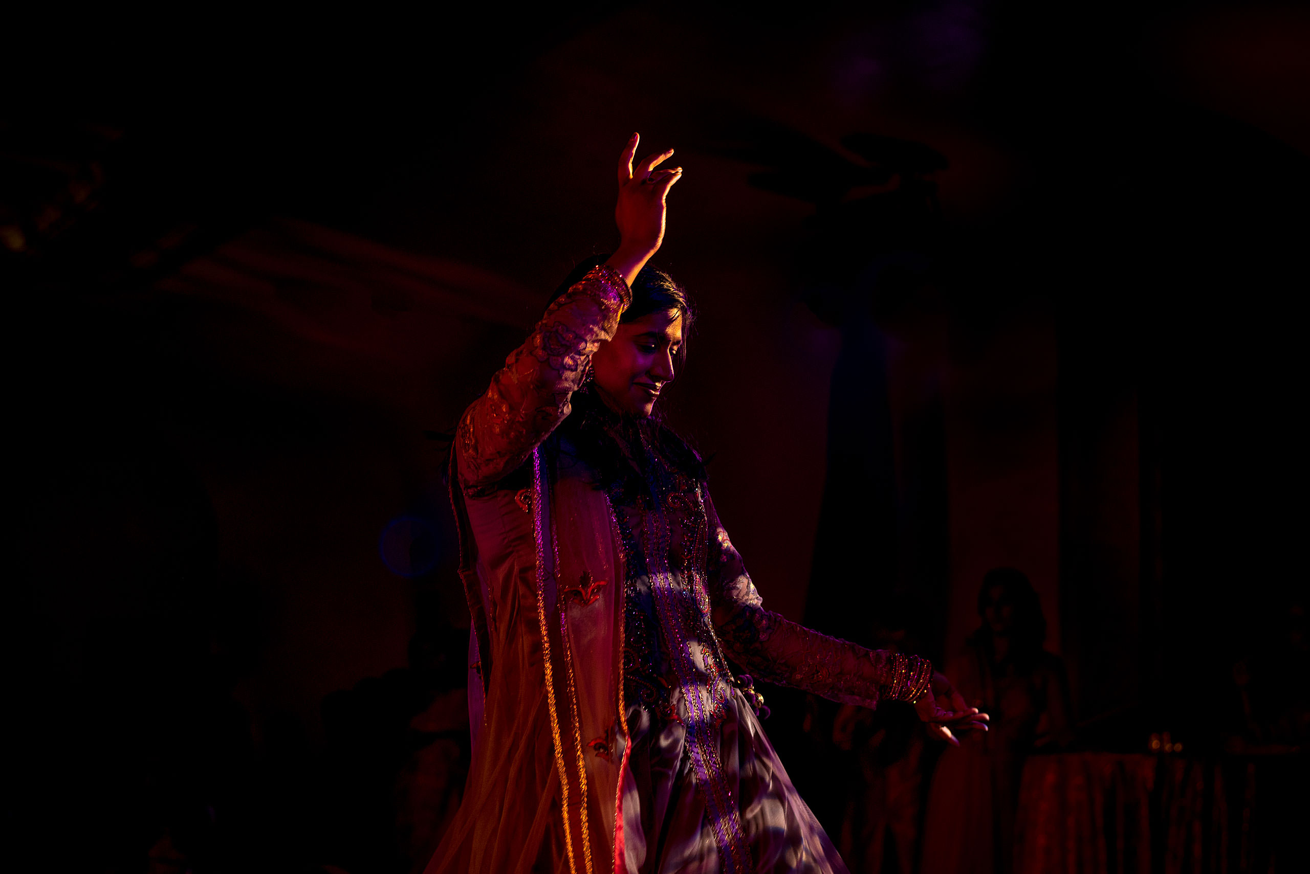 an indian women in a red dress dancing for cascade ballroom banff springs wedding by sean leblanc