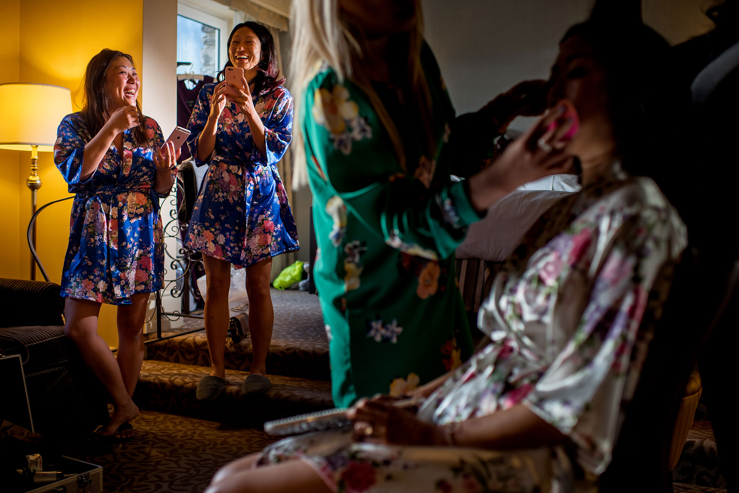 friends laughing the background while a bride gets ready for cascade ballroom banff springs wedding by sean leblanc