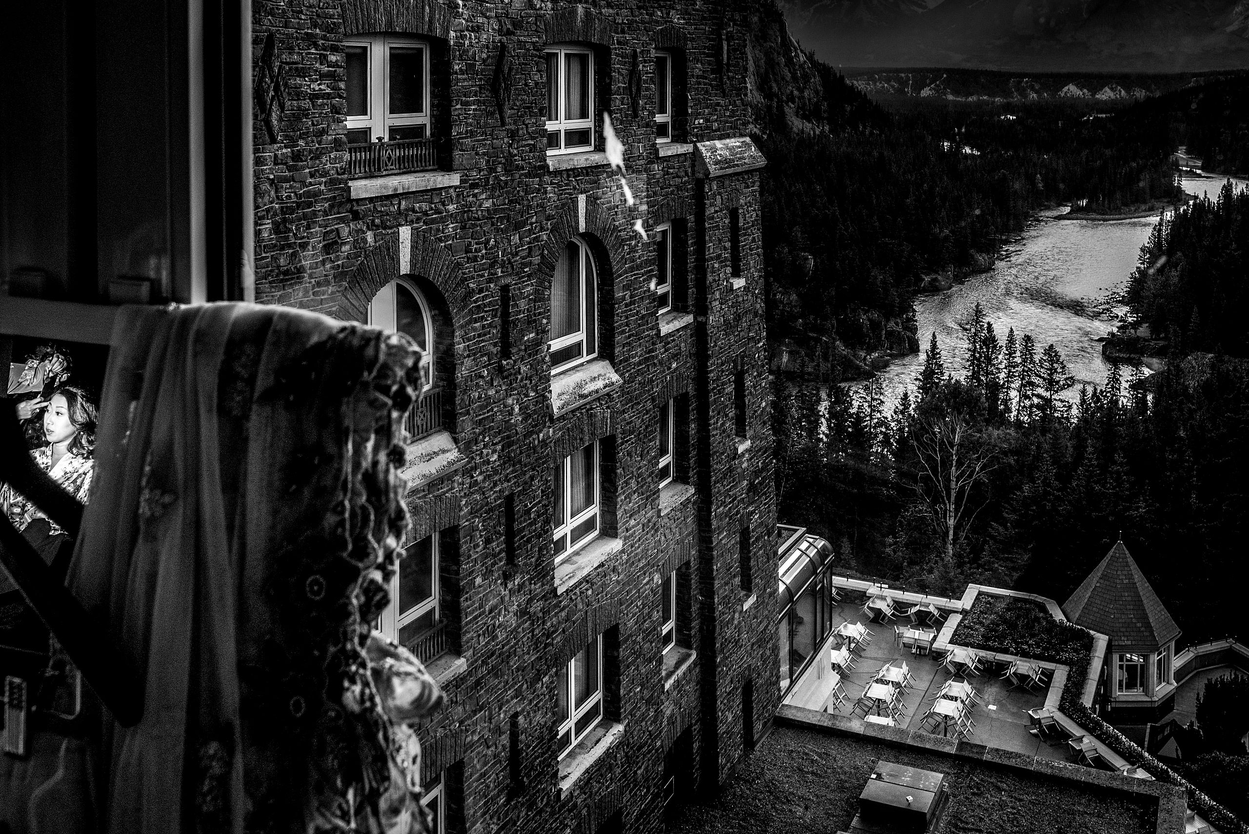 a river and hotel in the background while bride gets ready for cascade ballroom banff springs wedding by sean leblanc