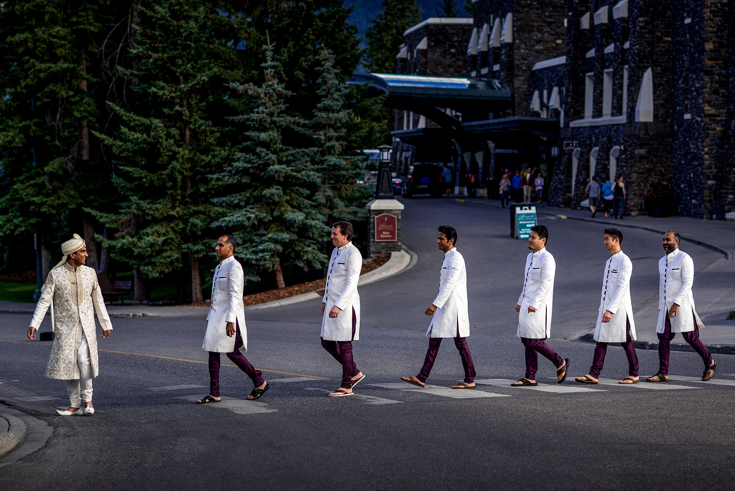 groomsmen walking across a road in single file for cascade ballroom banff springs wedding by sean leblanc