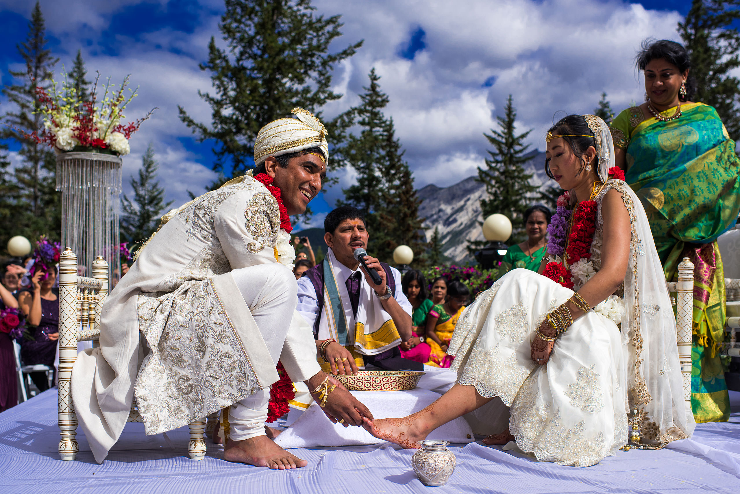 indian groom applying paint to brides foot for cascade ballroom banff springs wedding by sean leblanc