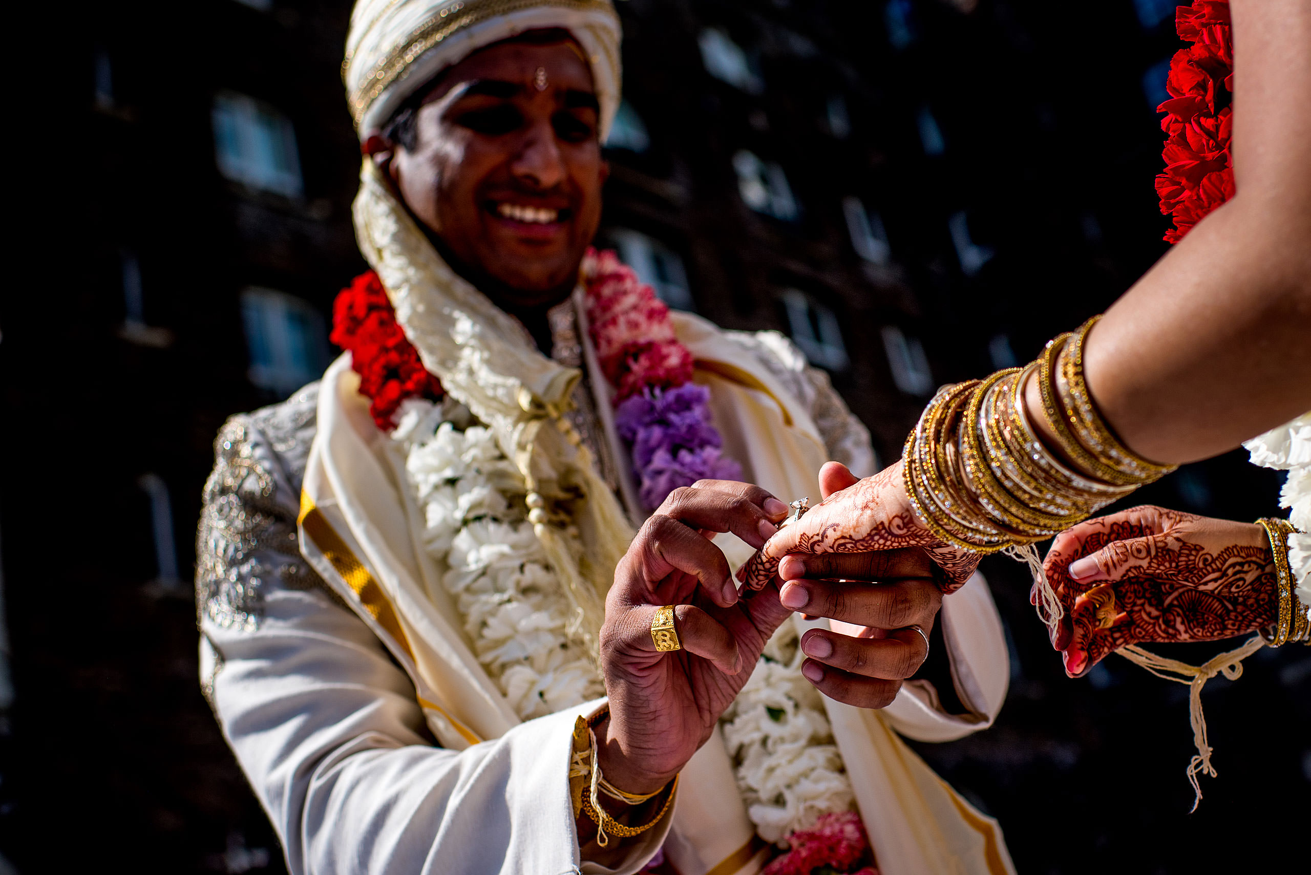 indian groom placing ring on brides finger for cascade ballroom banff springs wedding by sean leblanc