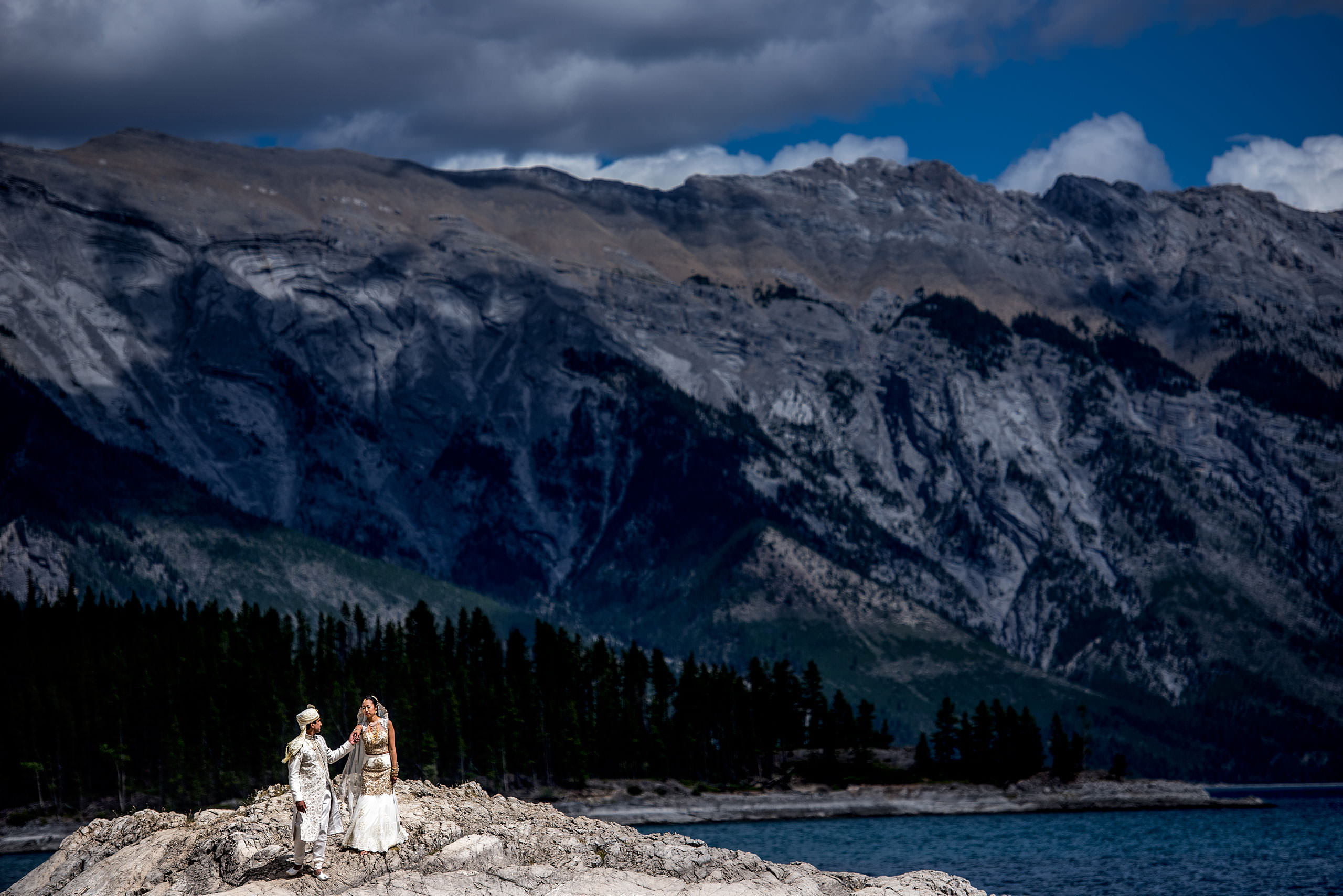 indian groom leading his bride down a mountain by Banff wedding photographer