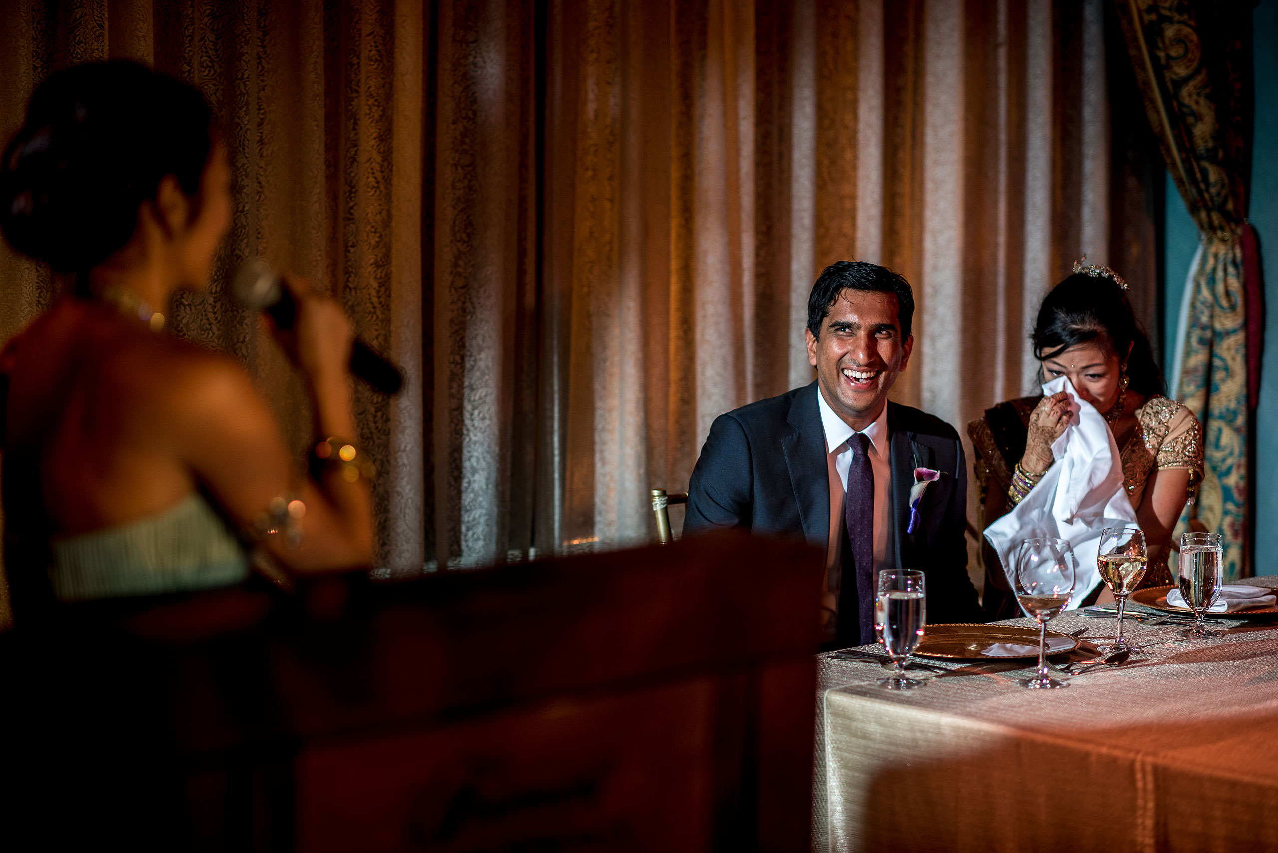 bride and groom laughing at speech during reception for cascade ballroom banff springs wedding by sean leblanc