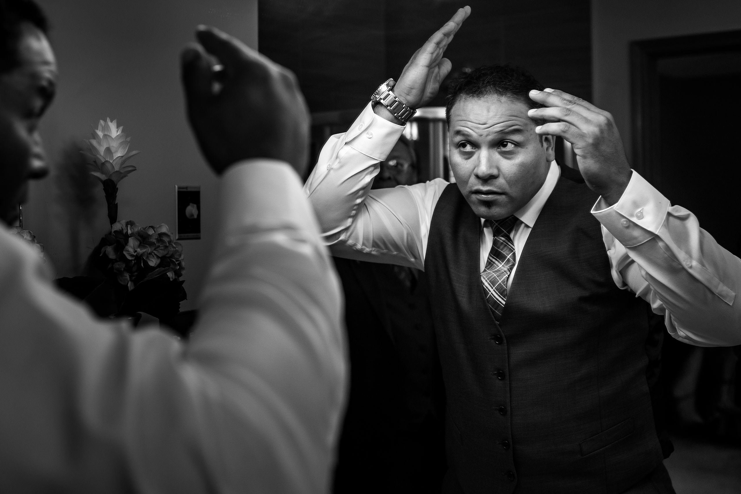 A groom getting ready by combing his hair by Edmonton wedding photographer sean leblanc