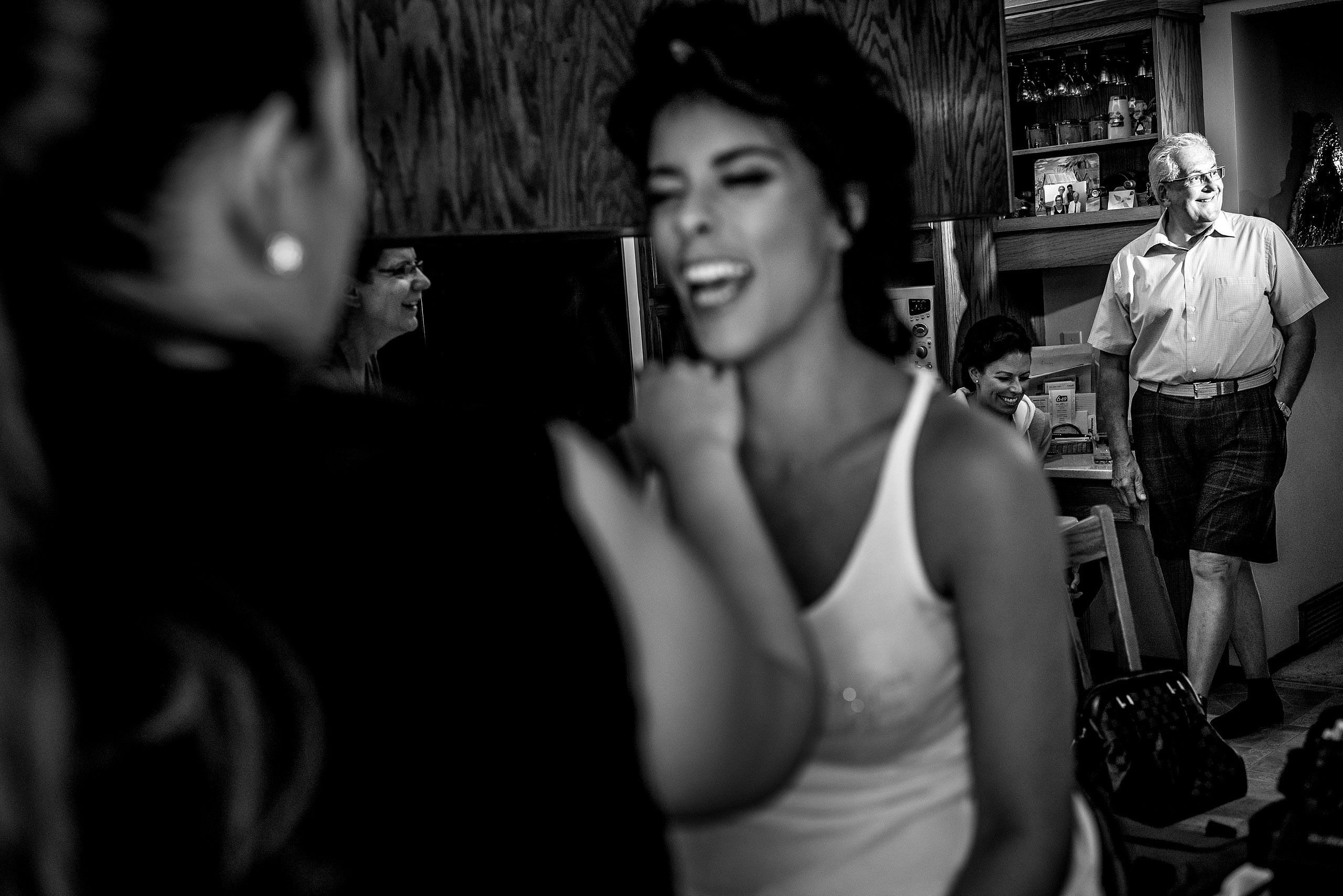 a bride laughing while getting her makeup applied by Edmonton wedding photographer sean leblanc