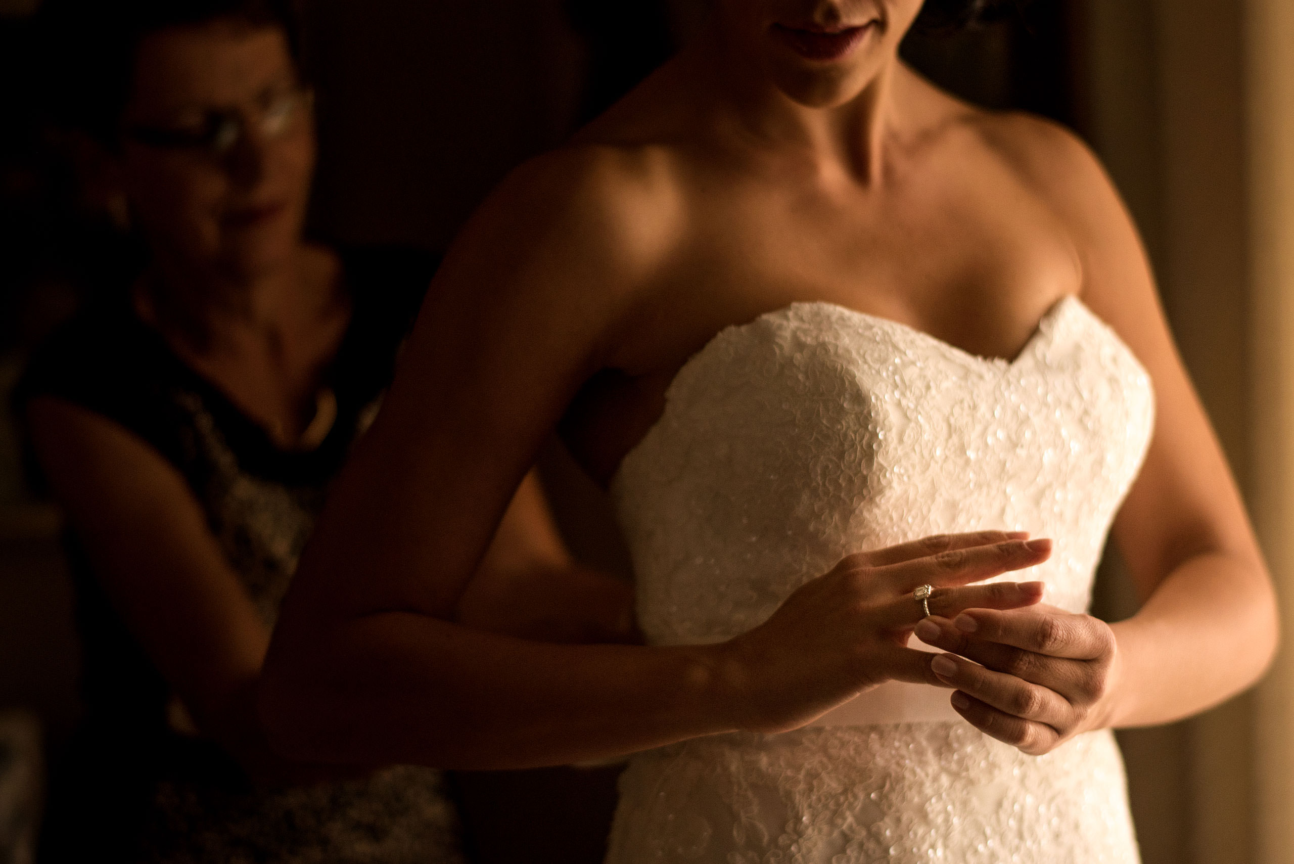 a bride adjusting her ring in front of a window by Edmonton wedding photographer sean leblanc