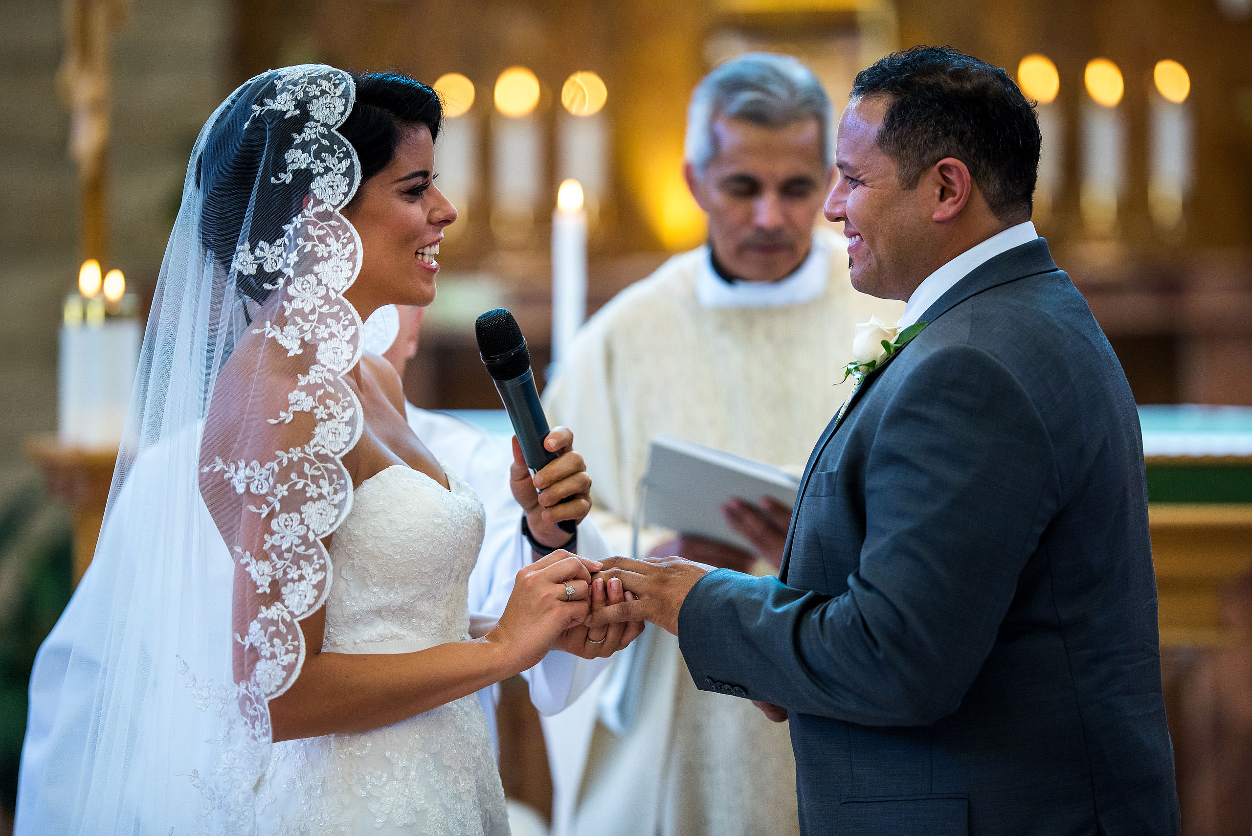 a bride placing a ring on her grooms finger by Edmonton wedding photographer sean leblanc