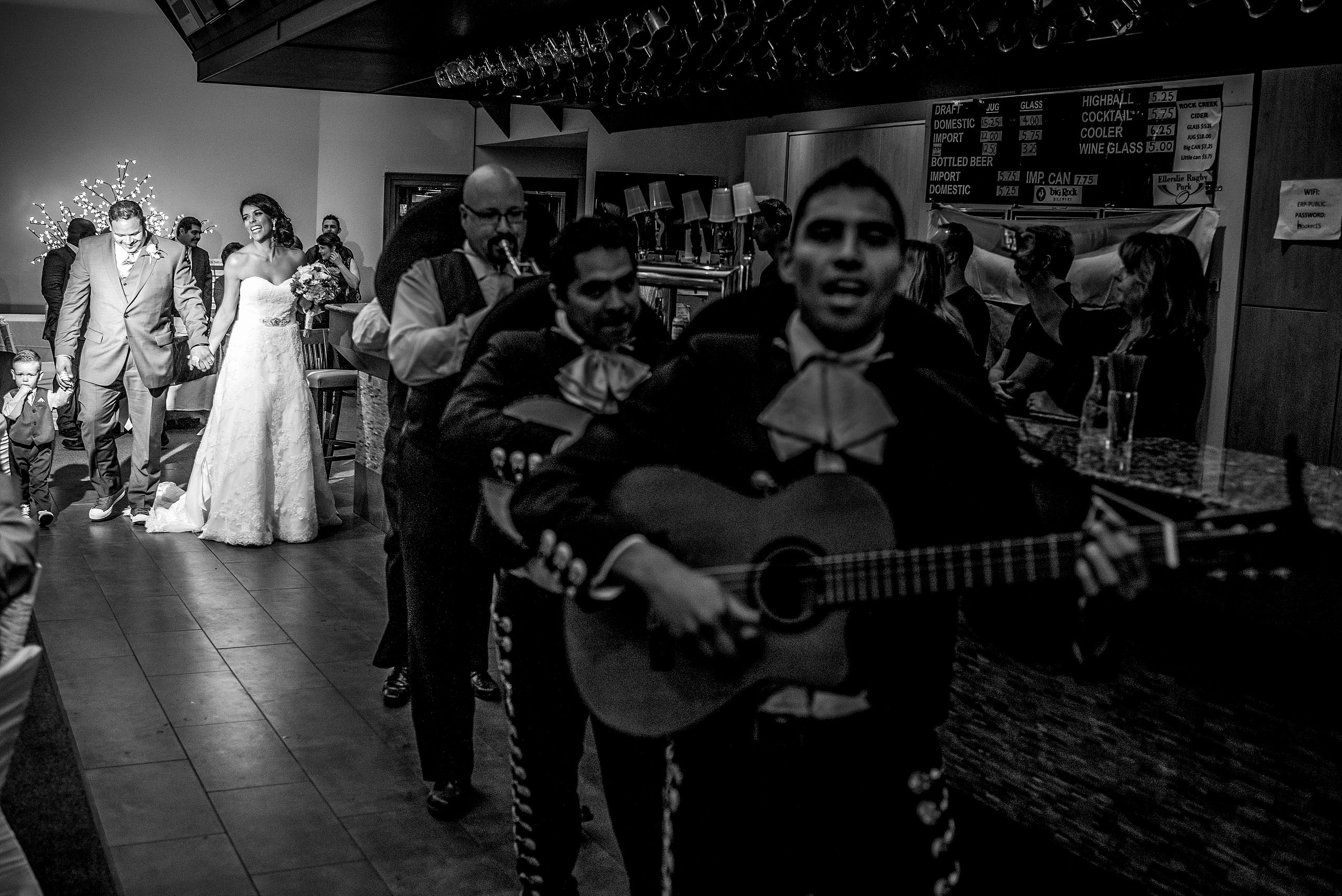 a bride and groom walking into a reception led by a mariachi band by Edmonton wedding photographer sean leblanc