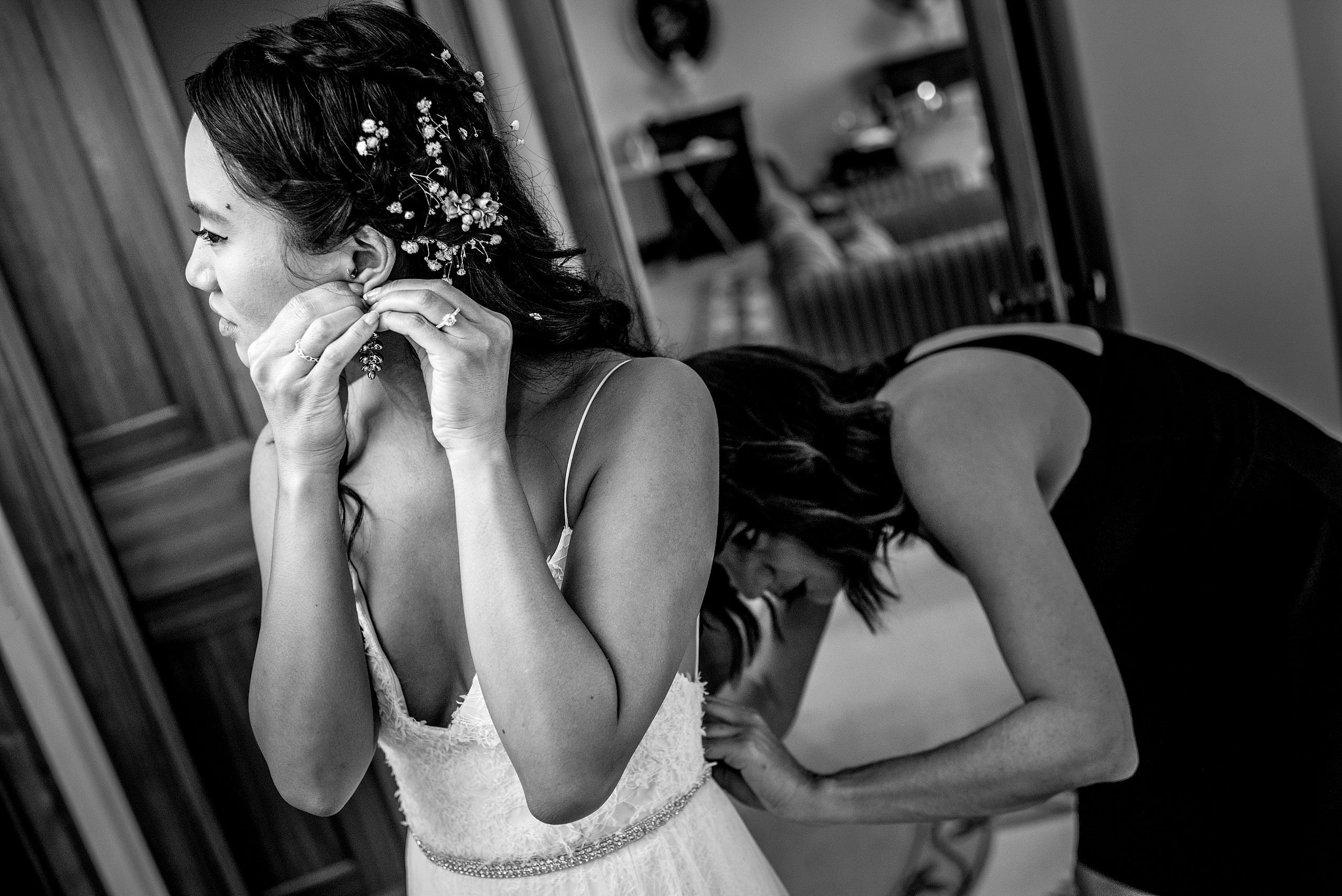 bridesmaid helping a bride with her dress at castillo hotel son vida destination wedding by sean leblanc