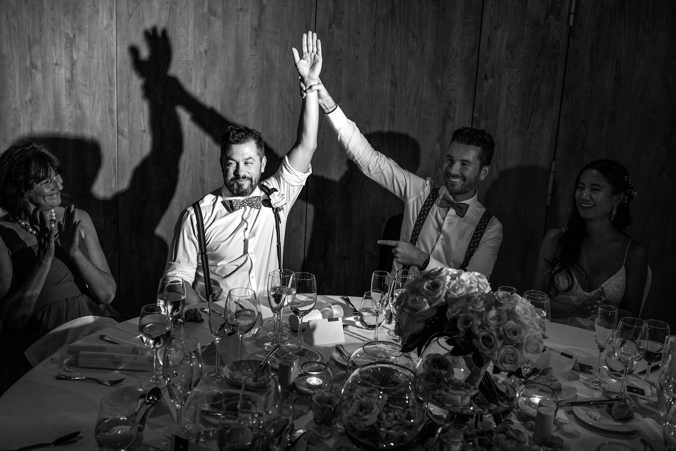 a groom holding up his groomsmen arm at the reception at castillo hotel son vida destination wedding by sean leblanc