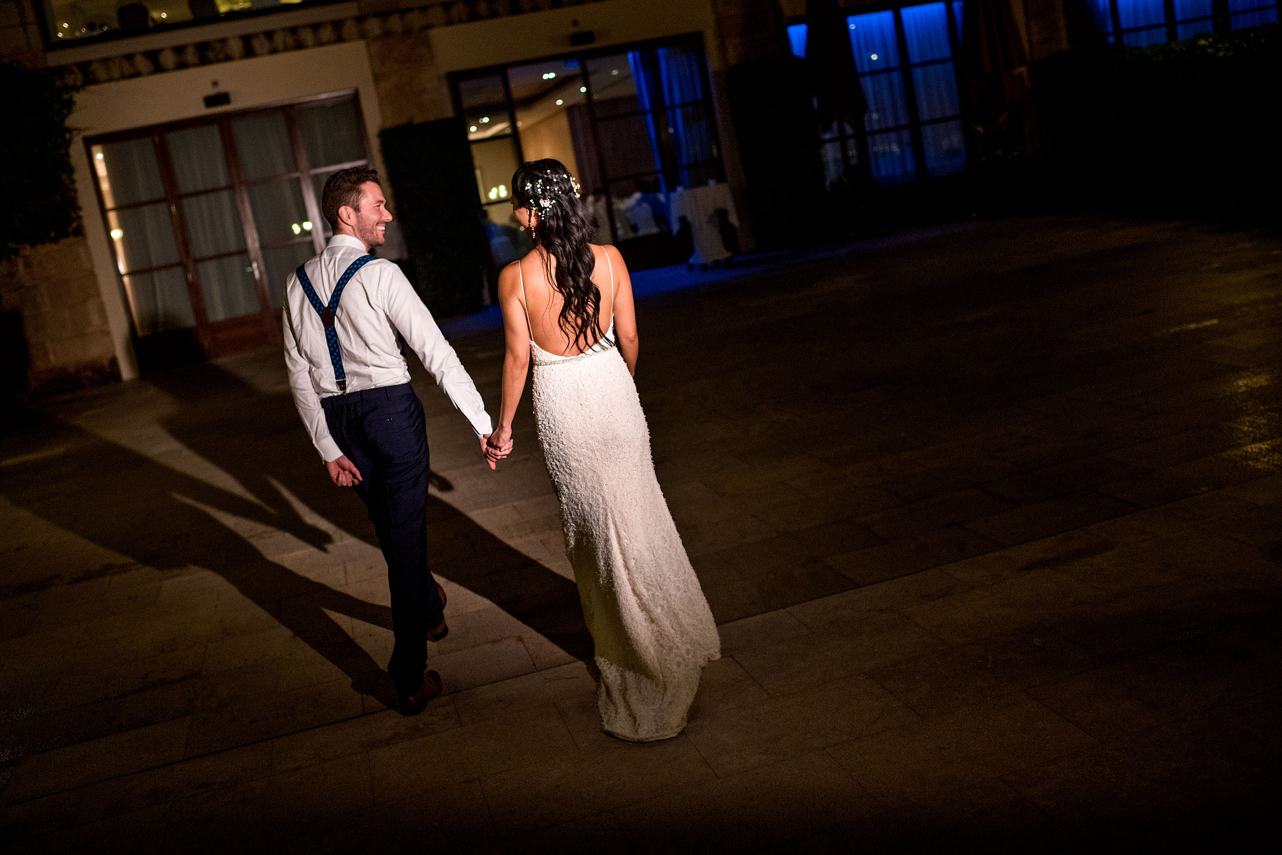 a bride and groom walking towards a building together at castillo hotel son vida destination wedding by sean leblanc