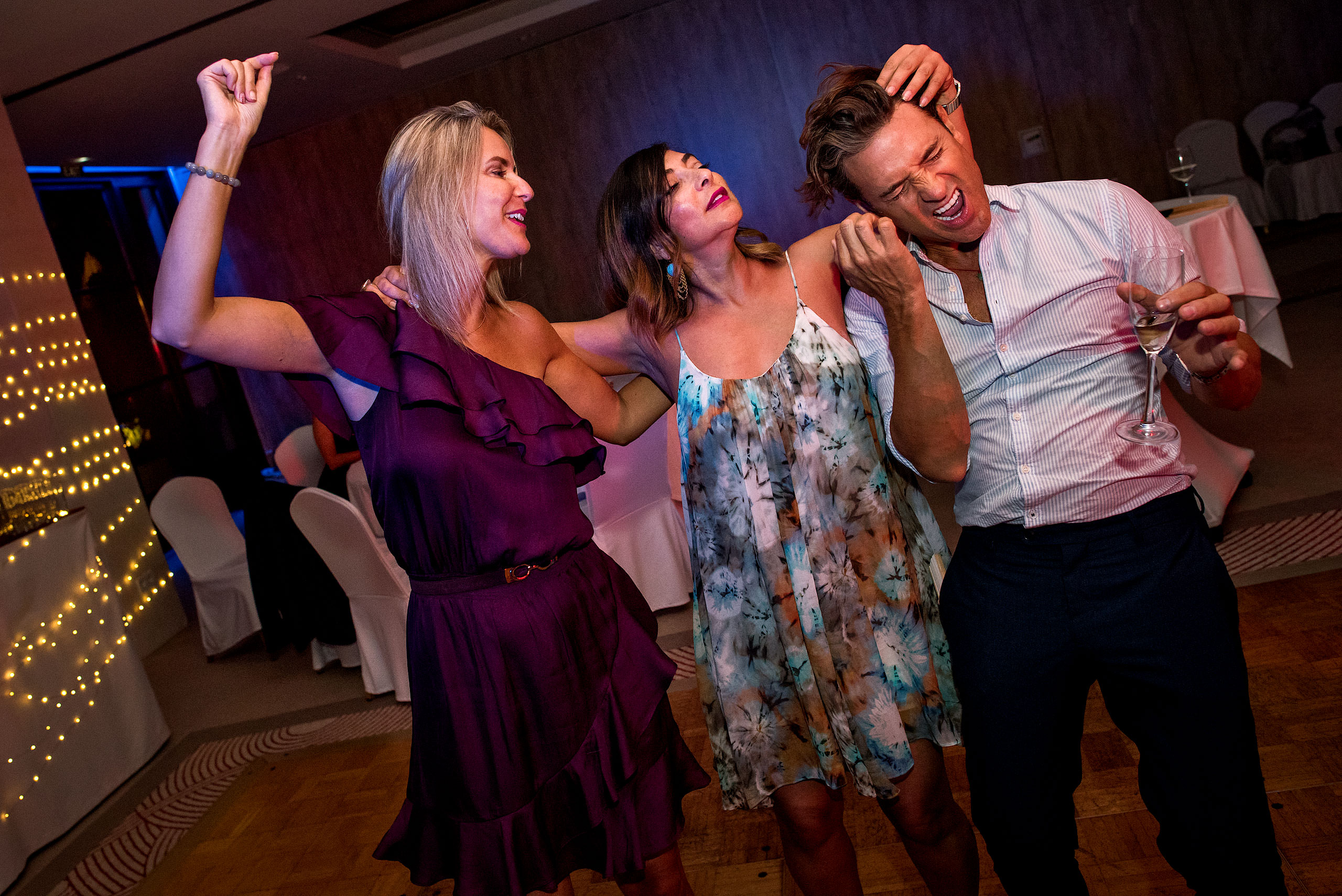 two women and one man dancing together at castillo hotel son vida destination wedding by sean leblanc