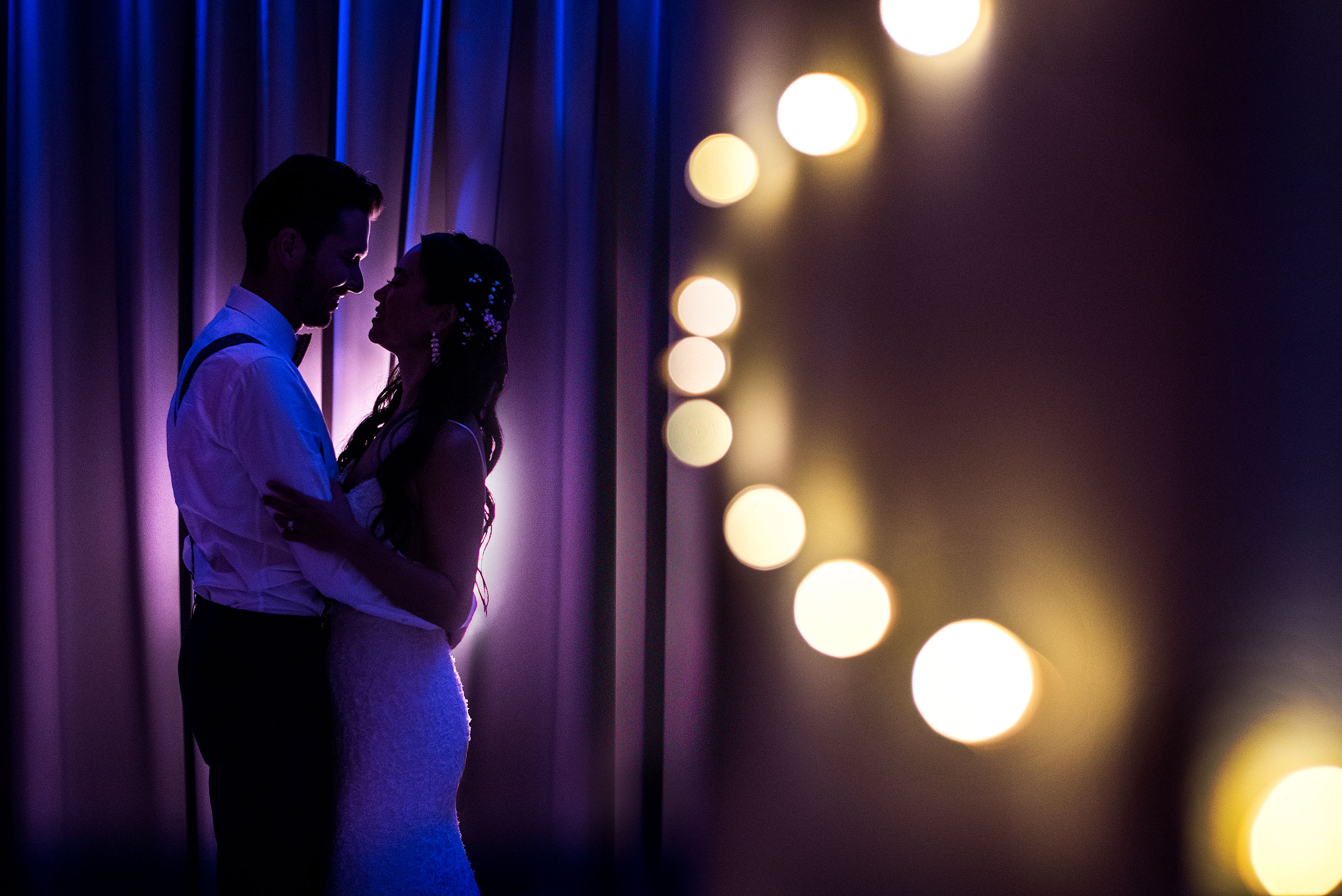 a bride and groom embracing each other in front of a curtain at castillo hotel son vida destination wedding by sean leblanc