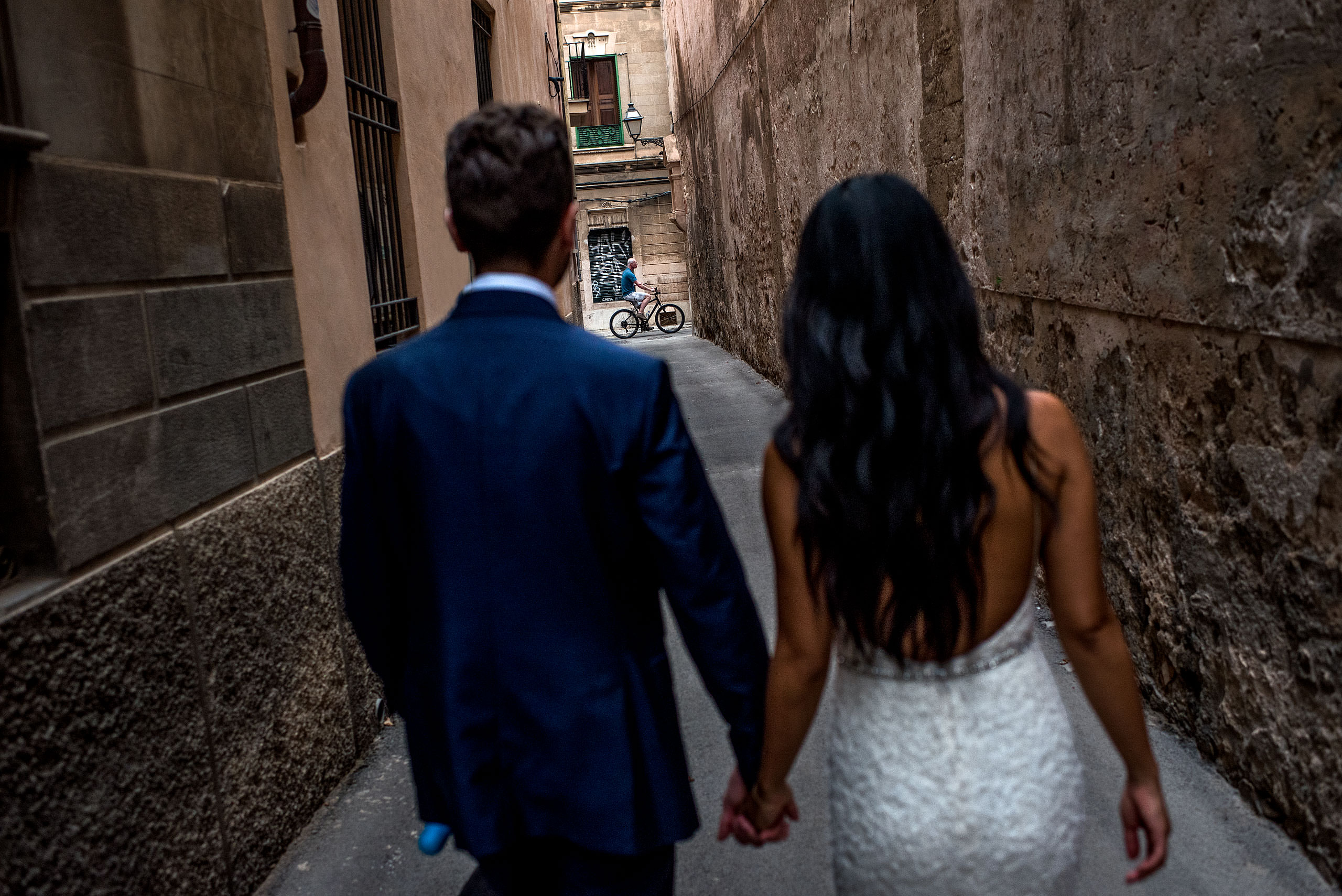 a bride and groom walking down an alleyway at castillo hotel son vida destination wedding by sean leblanc