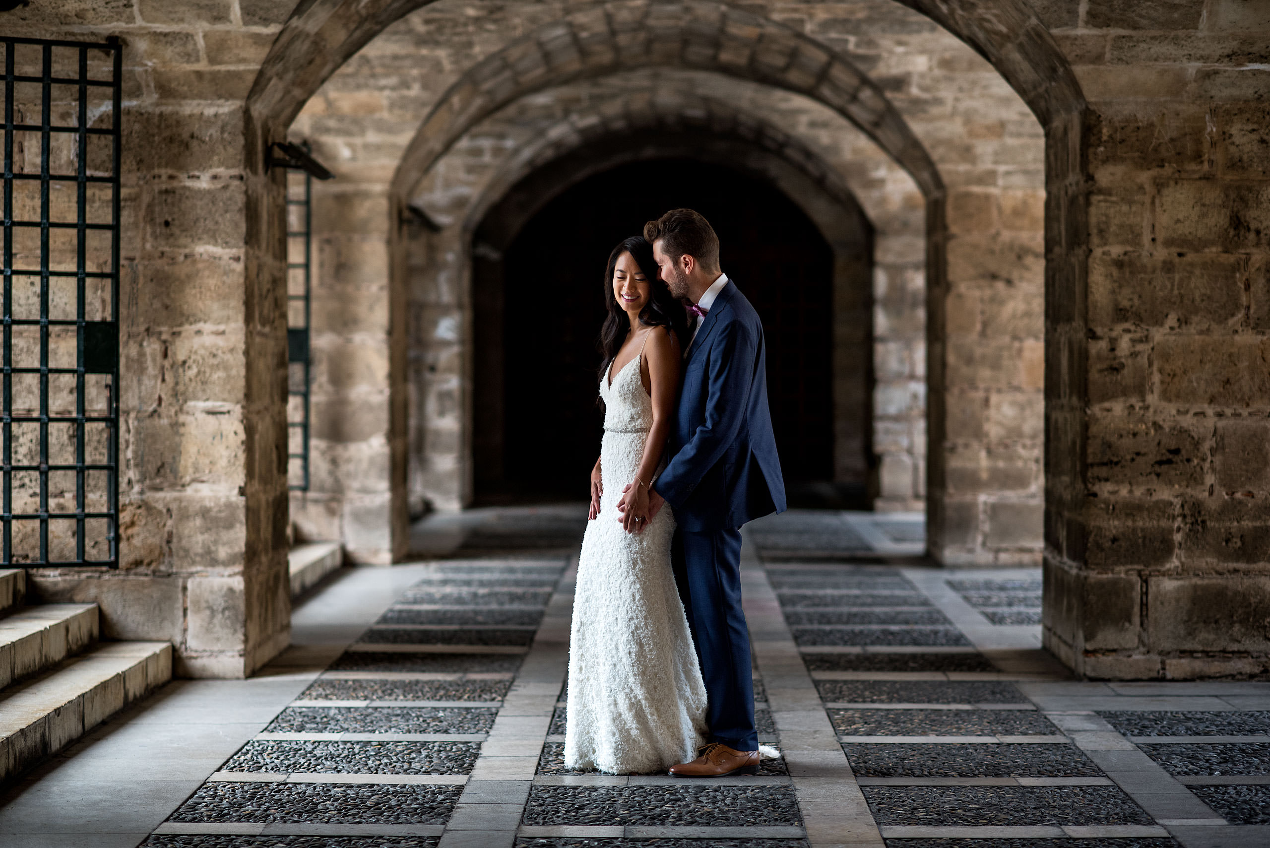 groom embracing his bride at an old castle at castillo hotel son vida destination wedding by sean leblanc