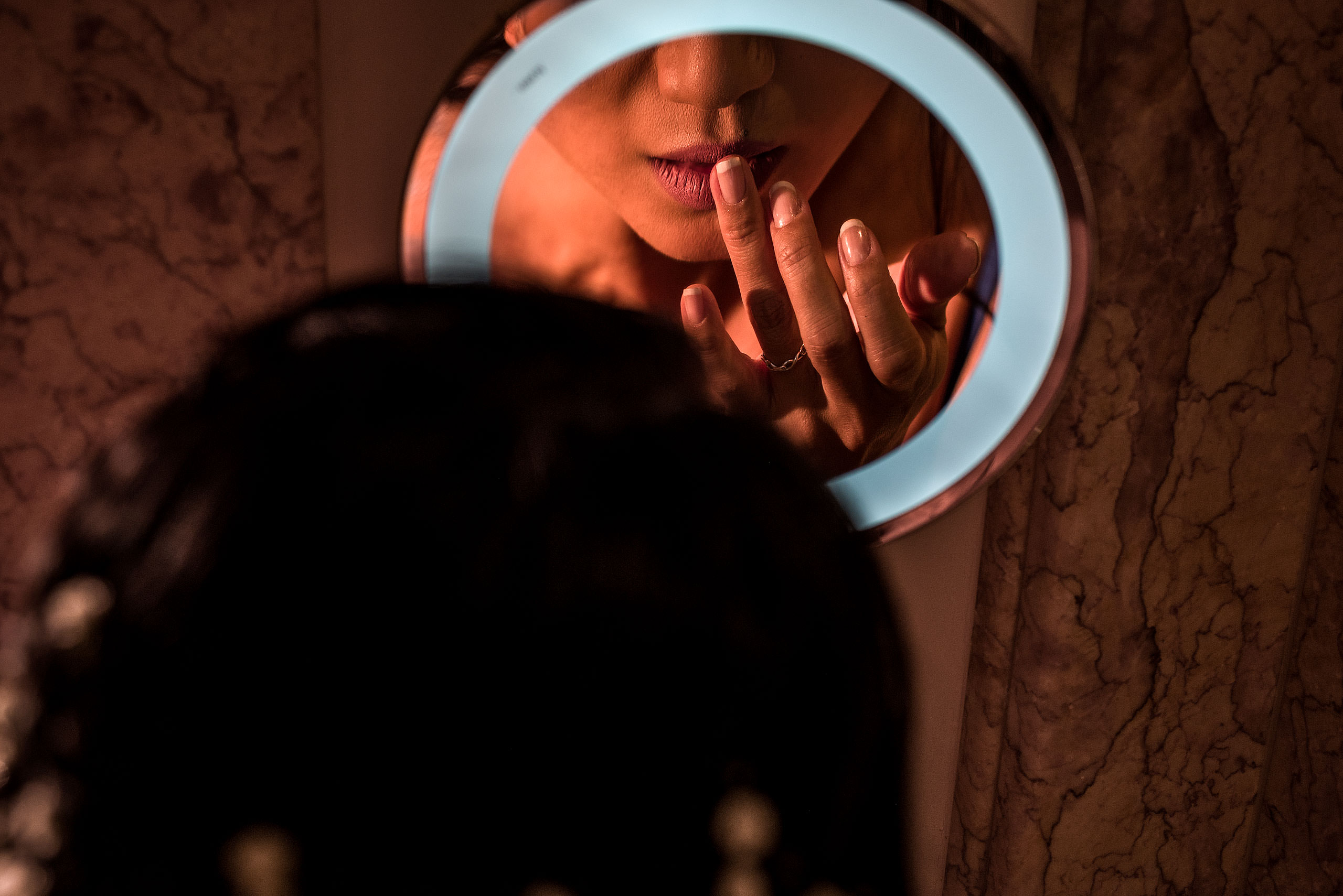 Bride putting on her lipstick in the mirror at castillo hotel son vida destination wedding by sean leblanc