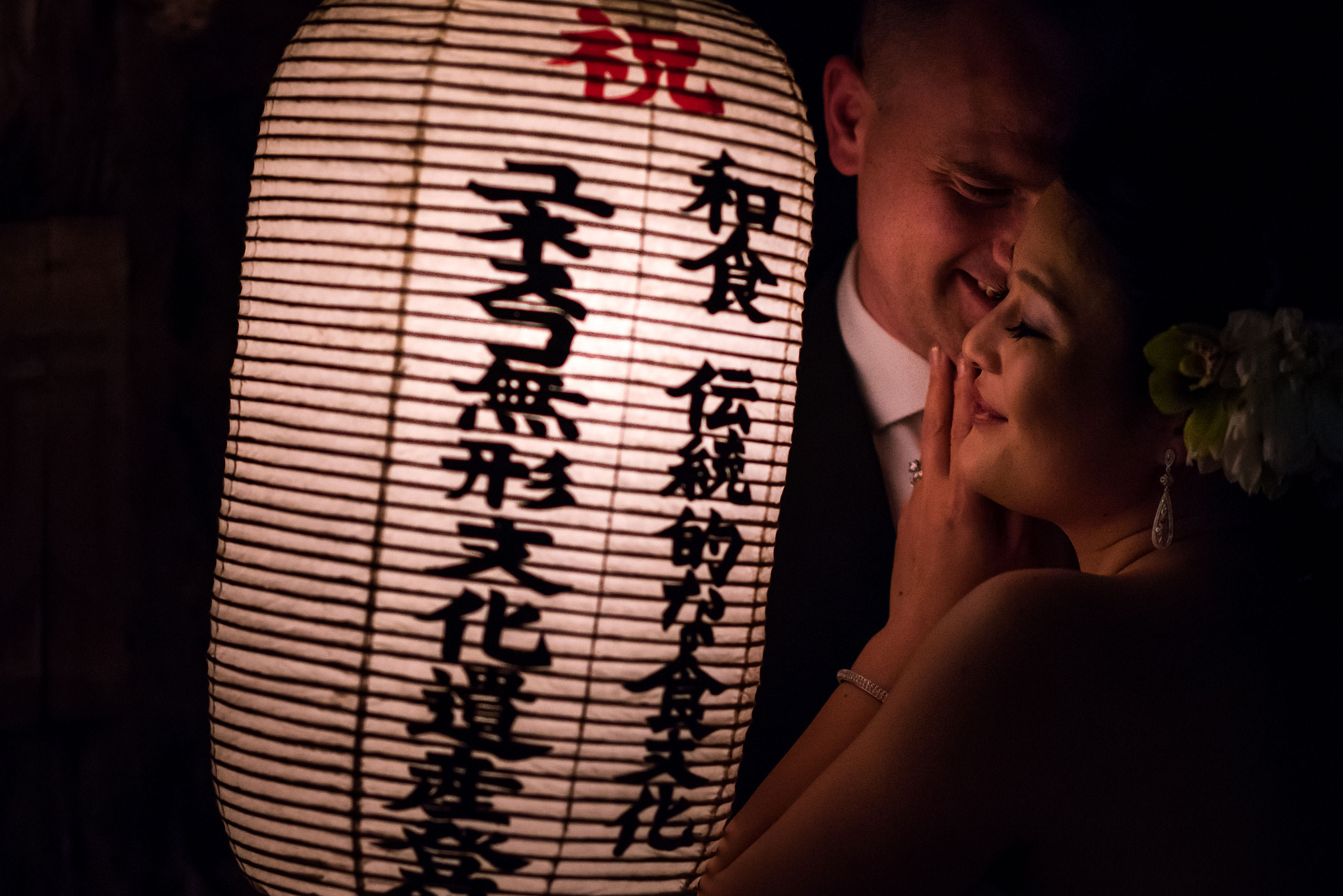 bride and groom hugging by a Japanese lantern by Japan Destination Wedding Photographer Sean LeBlanc