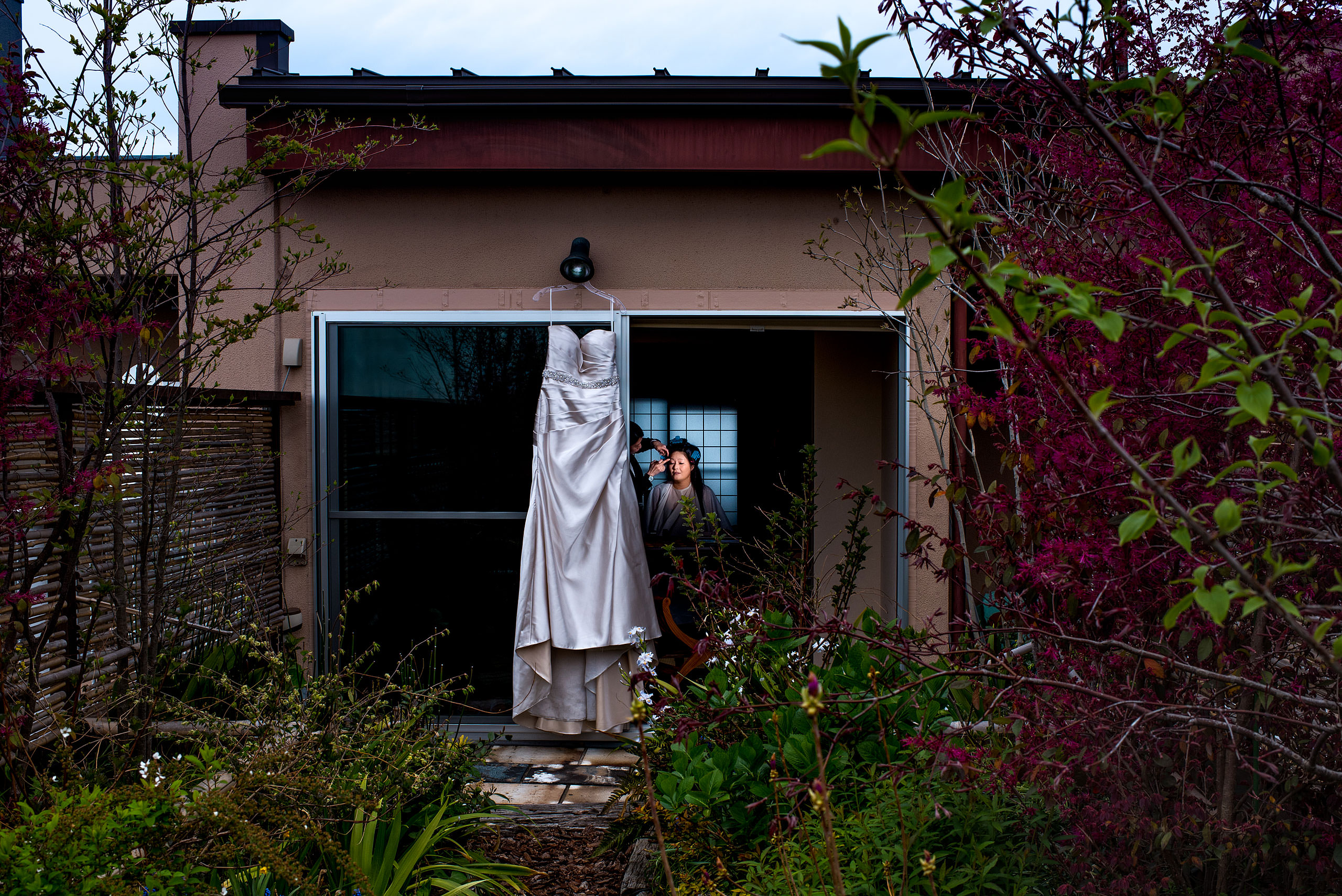 a wedding dress hanging off a building in front of a Japanese garden by Japan Destination Wedding Photographer Sean LeBlanc