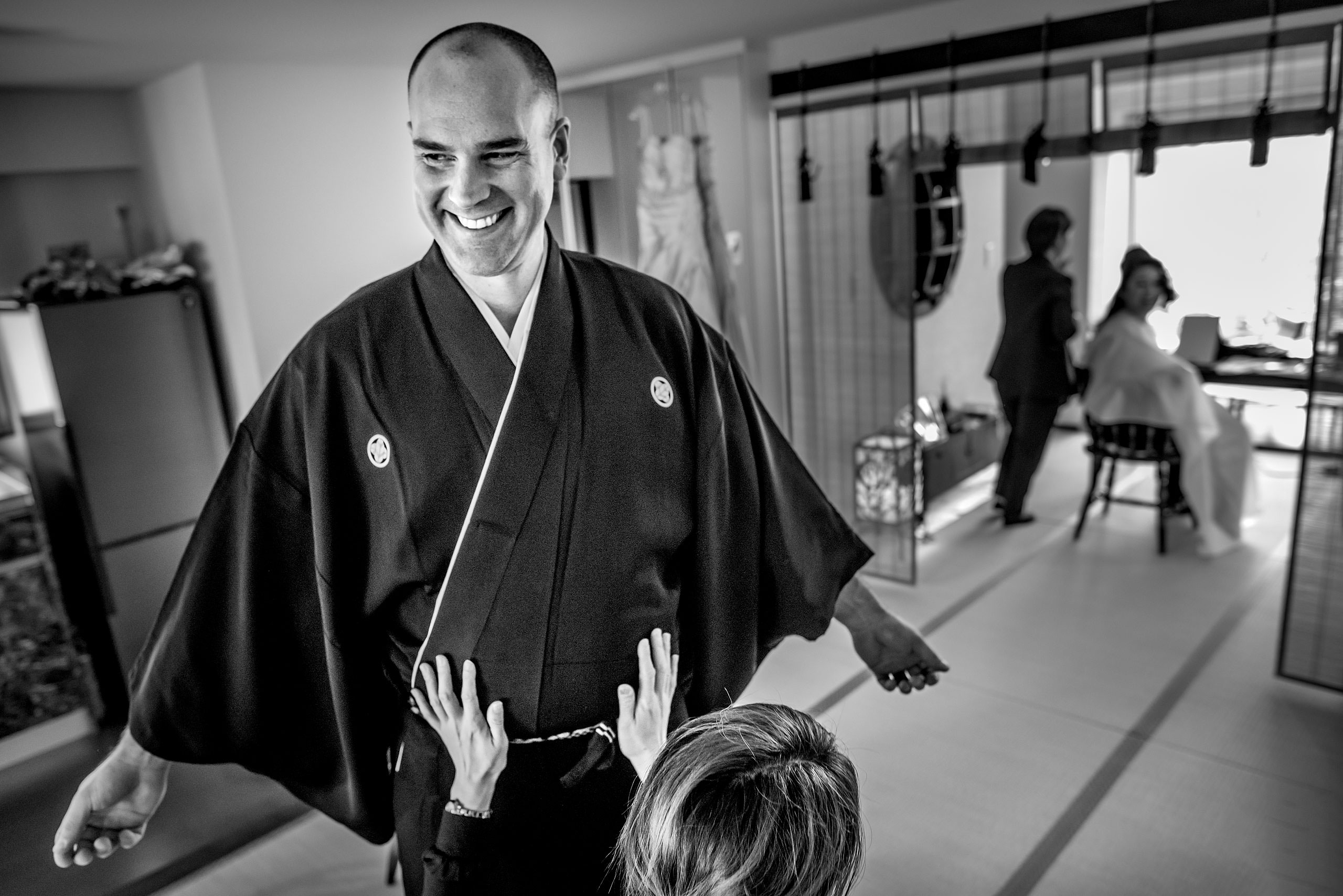 a groom getting help with his Japanese outfit by Japan Destination Wedding Photographer Sean LeBlanc