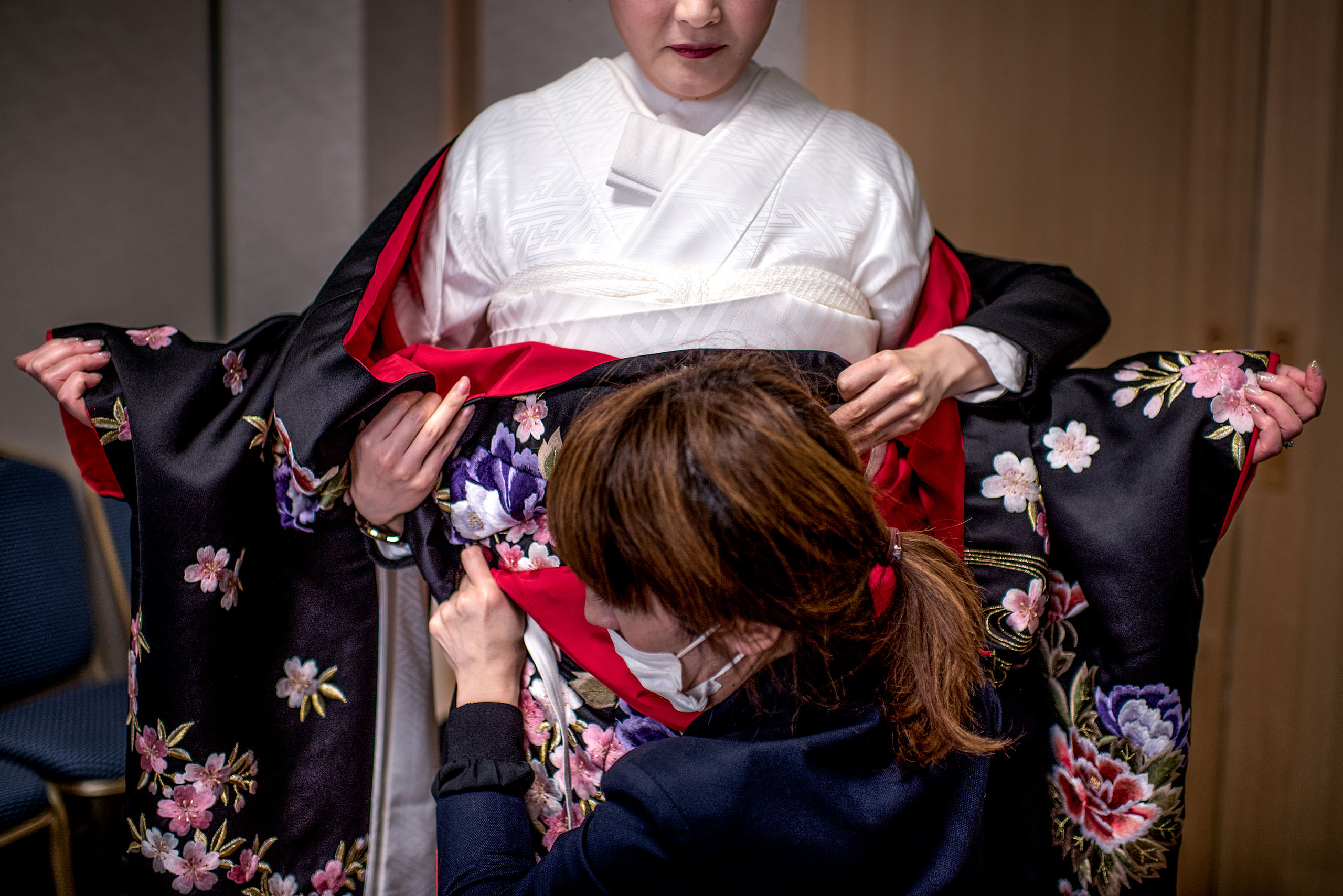 a Japanese women being helped with her kimono by Japan Destination Wedding Photographer Sean LeBlanc