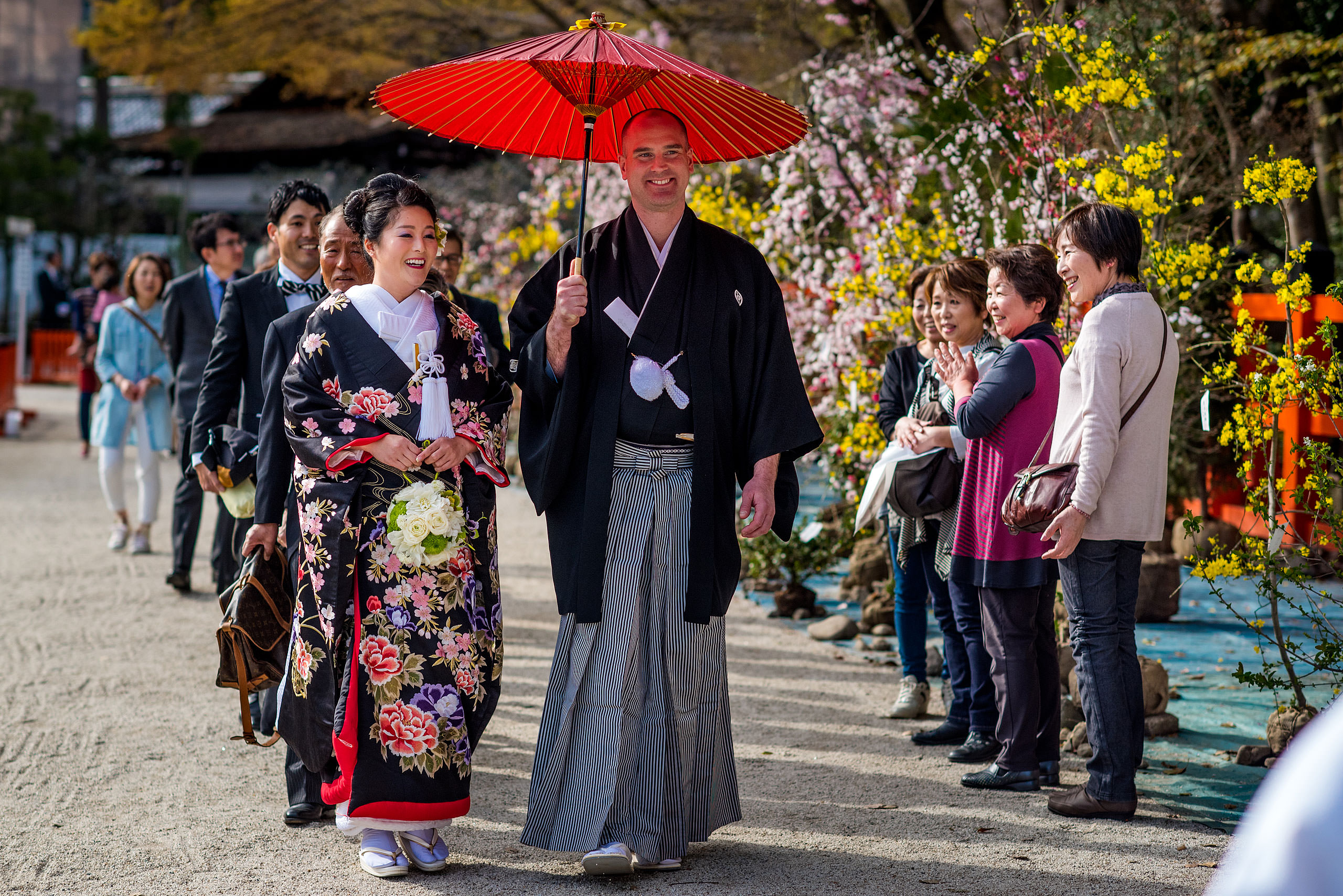 a Japanese bride and groom walking with umbrellas by Japan Destination Wedding Photographer Sean LeBlanc