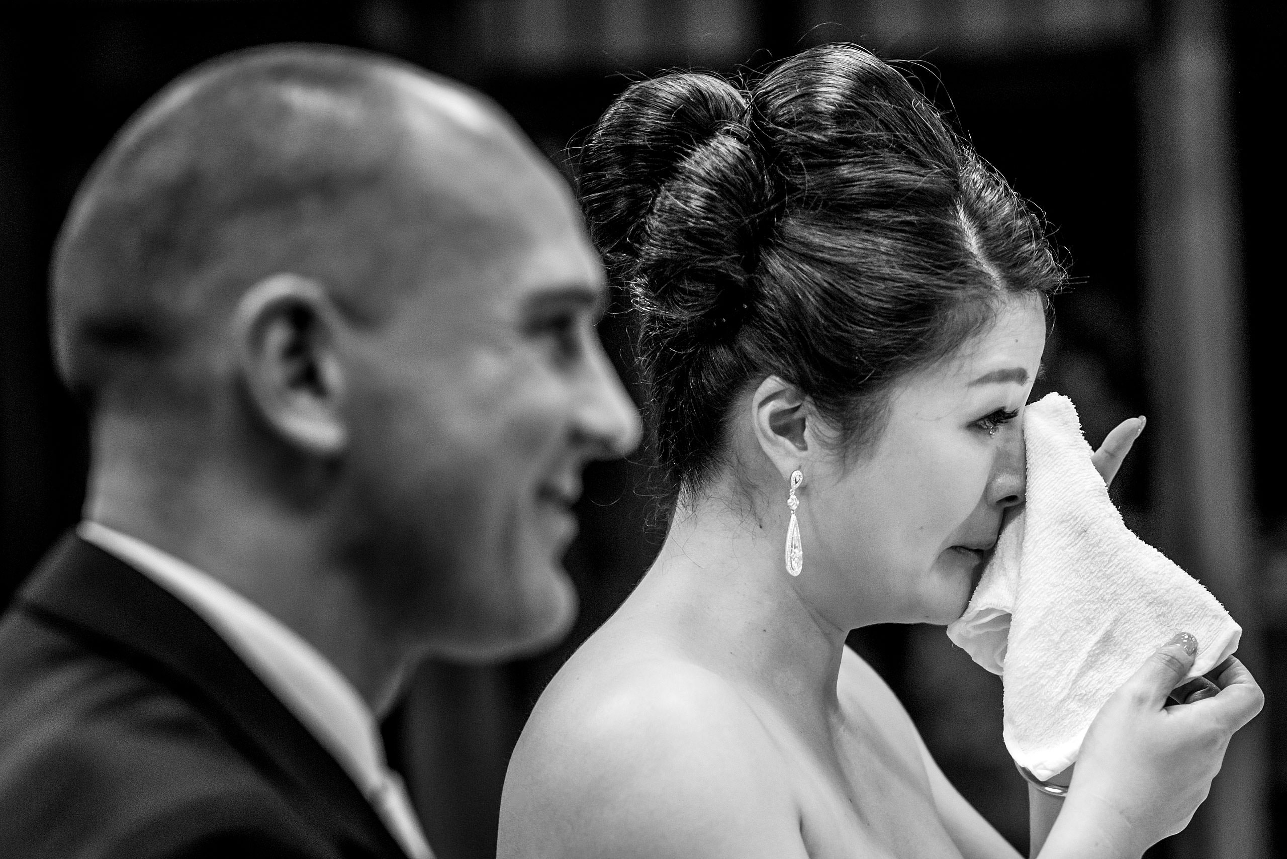 an emotional bride wiping a tear from her face by Japan Destination Wedding Photographer Sean LeBlanc