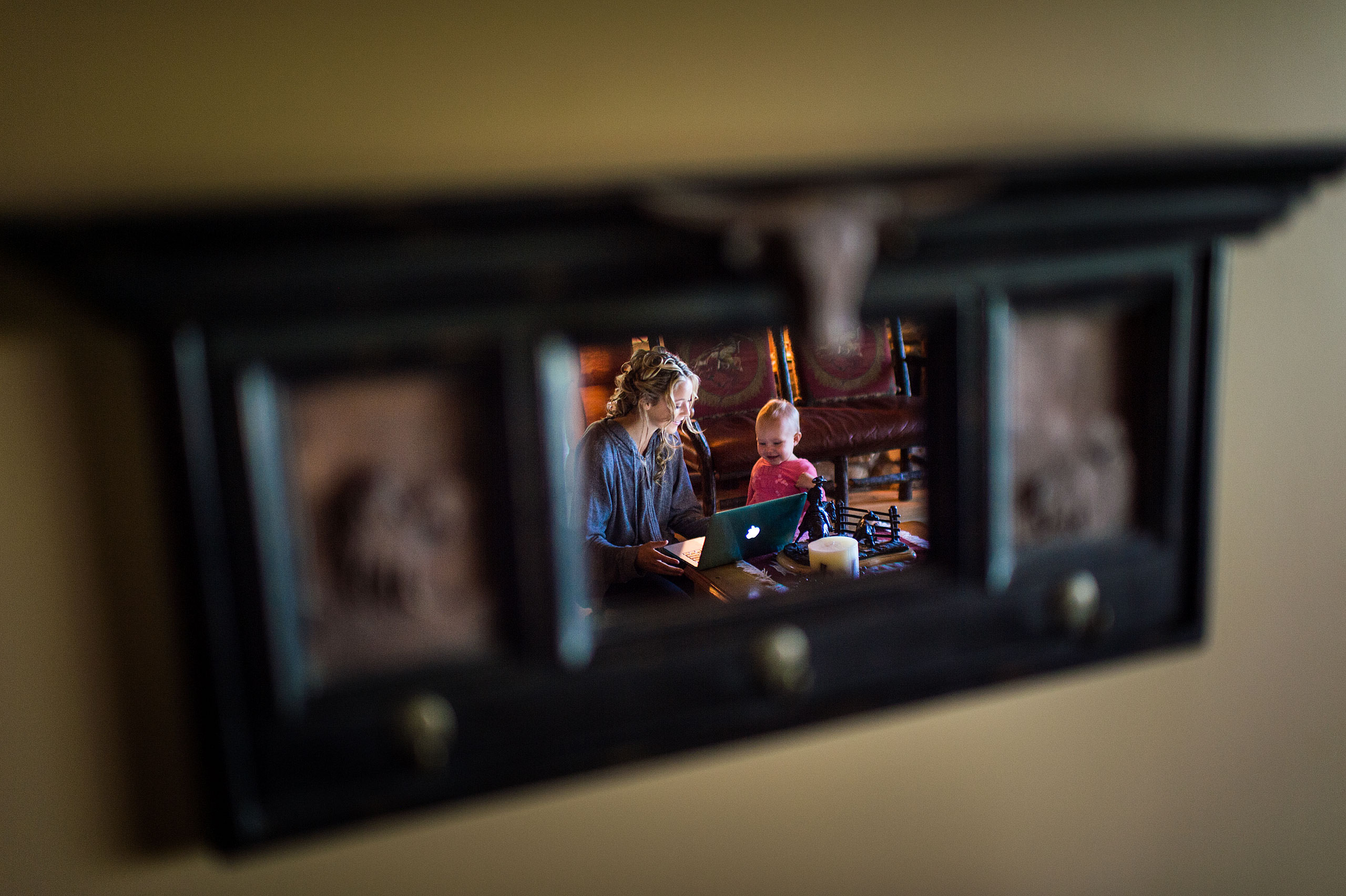 a reflection in a mirror of a girl playing with a baby at Cochrane Country Wedding by Sean LeBlanc