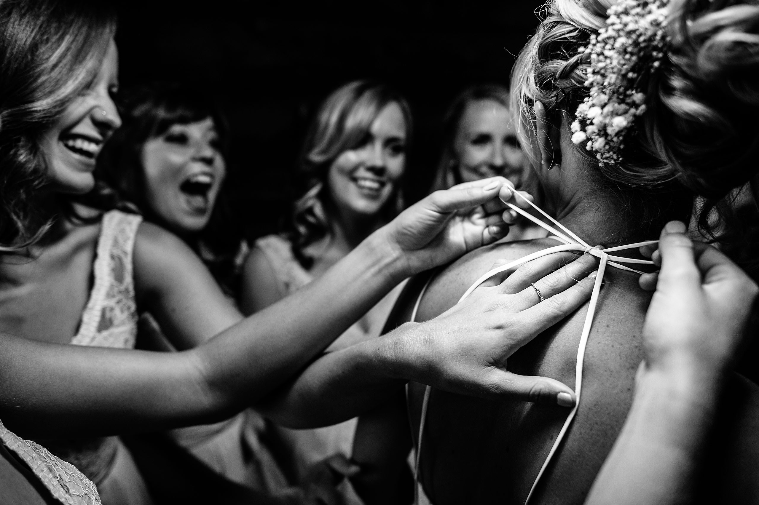 bridesmaids helping a bride get ready in her wedding dress at Cochrane Country Wedding by Sean LeBlanc