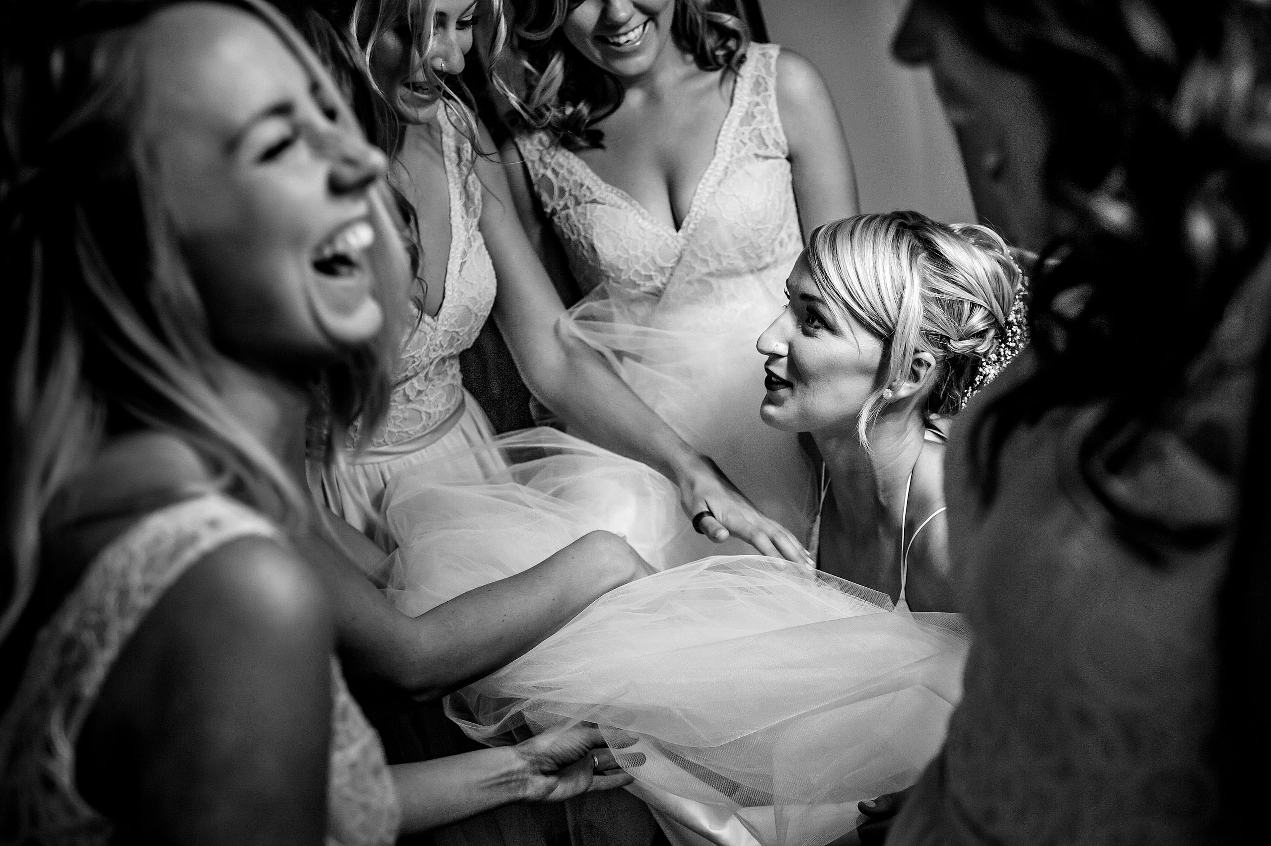 bridesmaids helping a bride with her dress at Cochrane Country Wedding by Sean LeBlanc