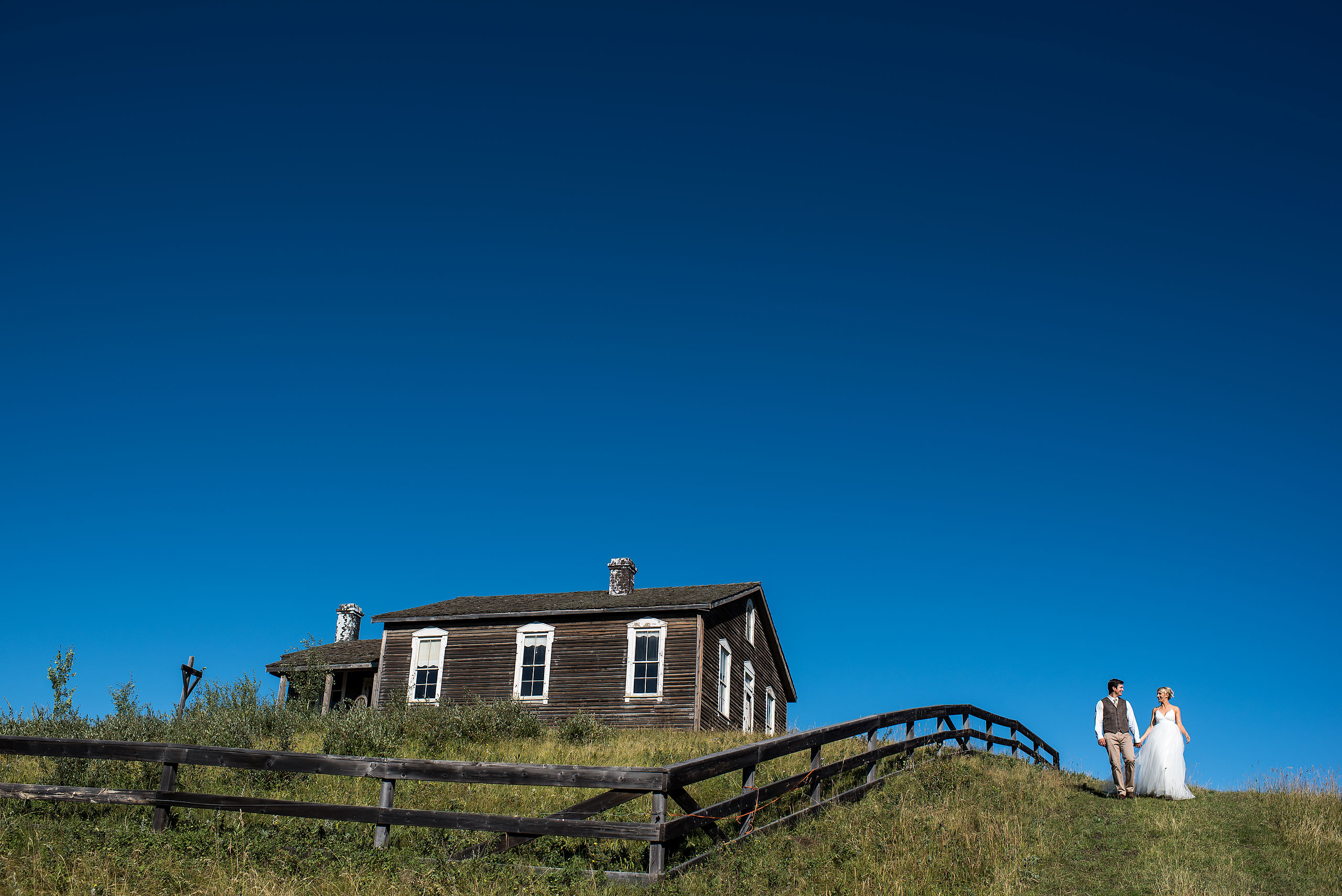 a bride and groom walking down the set of the Jesse James at Cochrane Country Wedding by Sean LeBlanc