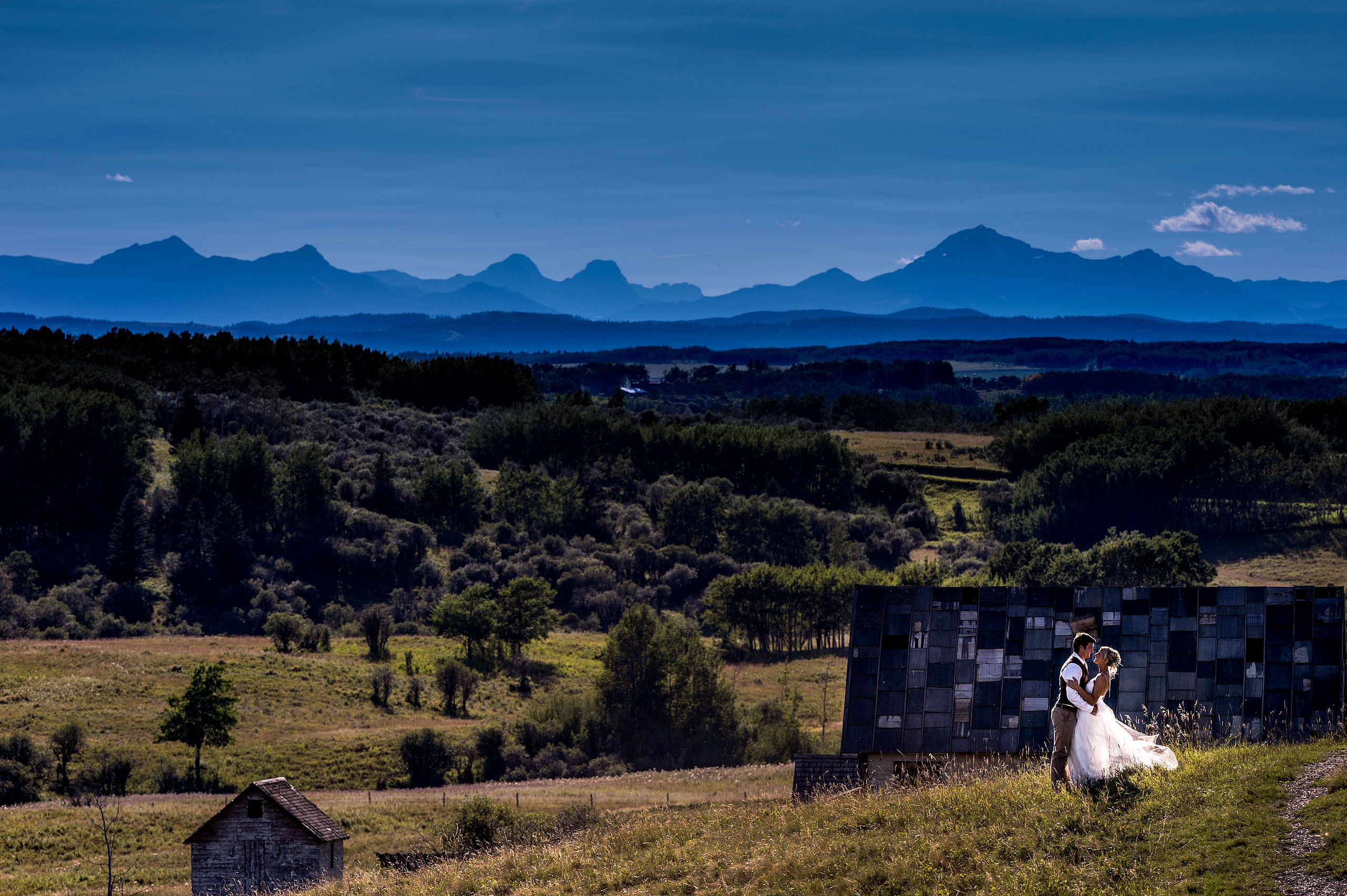 bride and groom posing with the mountains in the background by top calgary wedding photographer sean leblanc