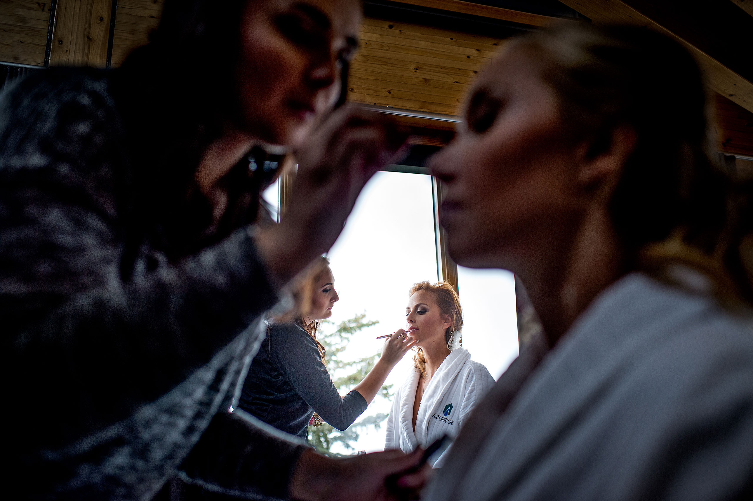 a bride getting makeup applied to her face at Priddis Azuridge Wedding by sean leblanc