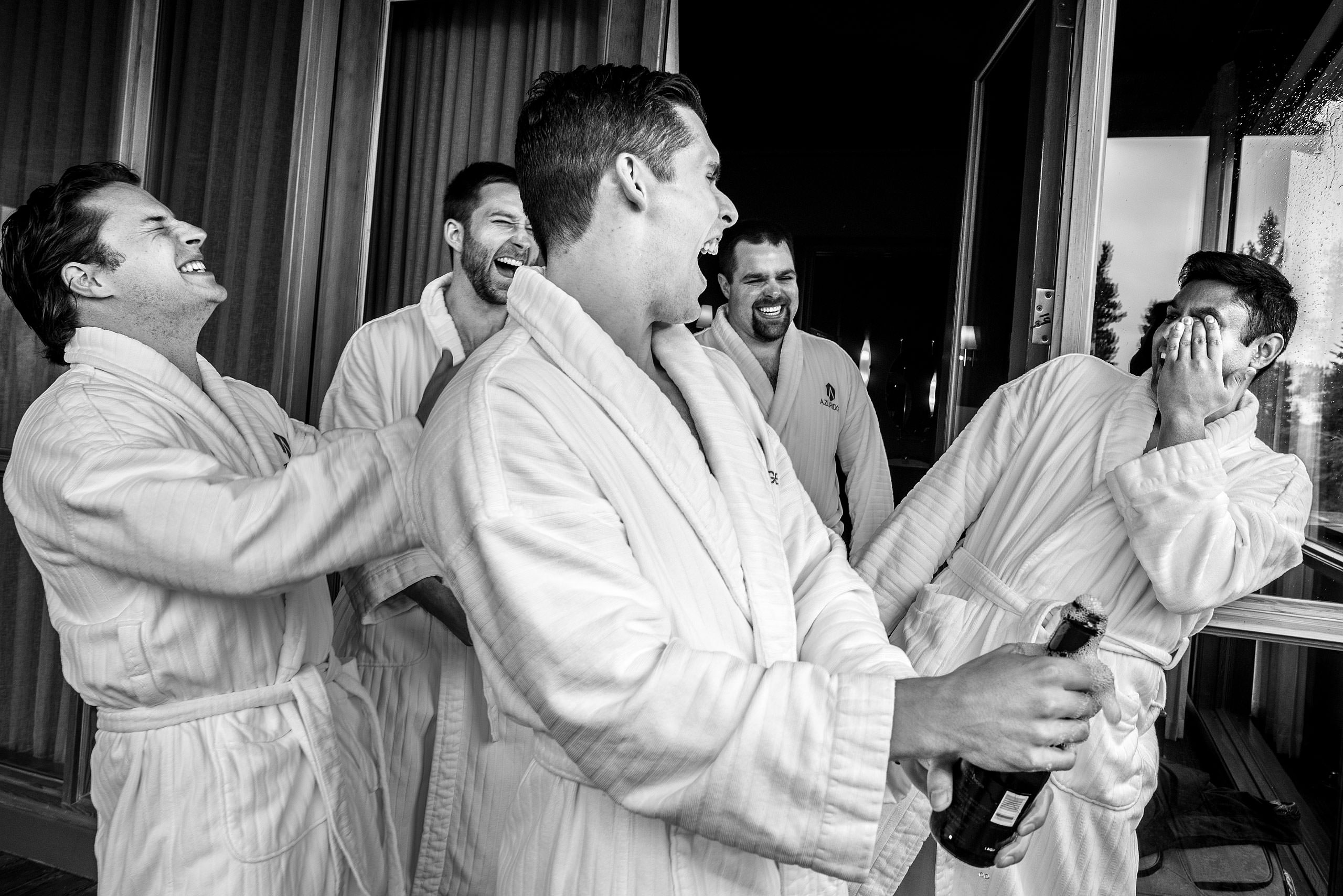 groomsmen laughing at each other in their bathrobe at Priddis Azuridge Wedding by sean leblanc